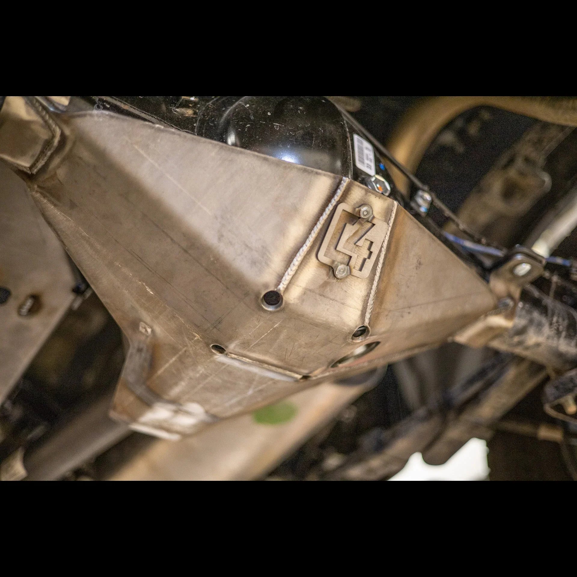 Steel off-road skid plate installed under a vehicle for undercarriage protection