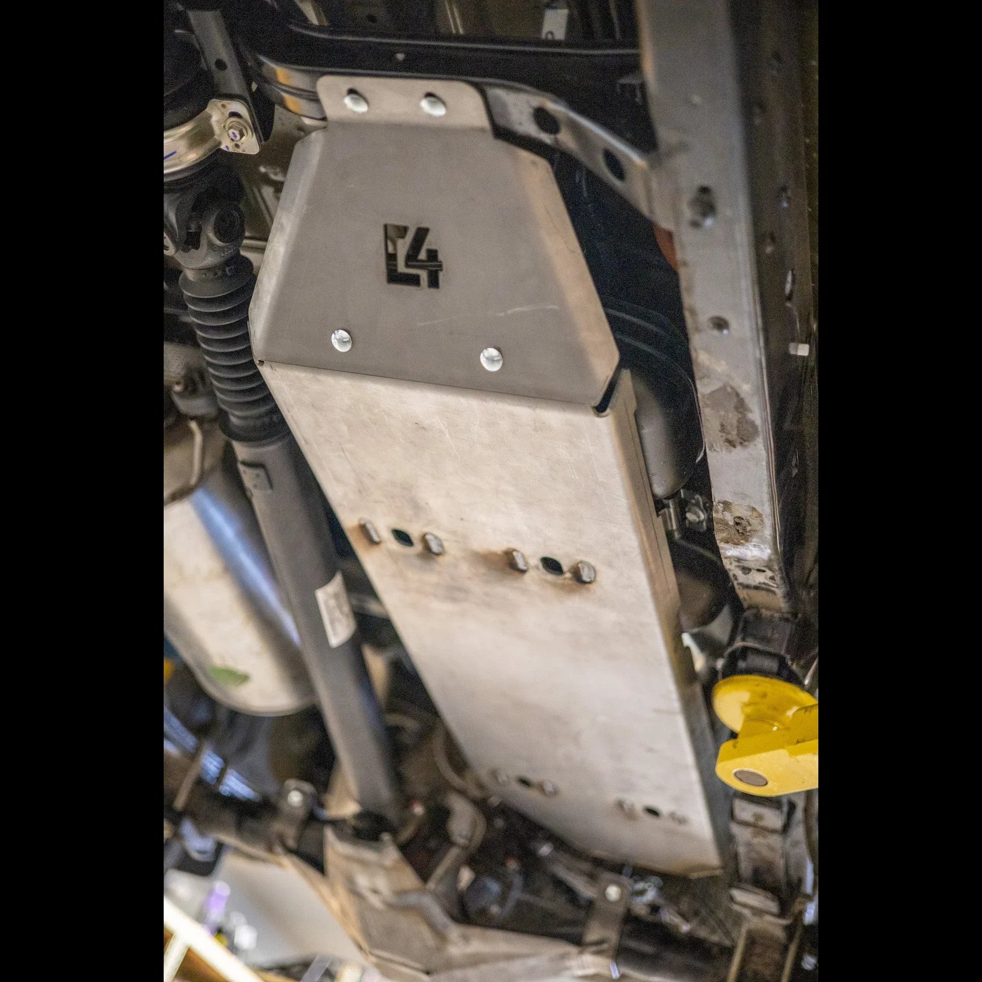 Aluminum skid plate installed on vehicle undercarriage for off-road protection