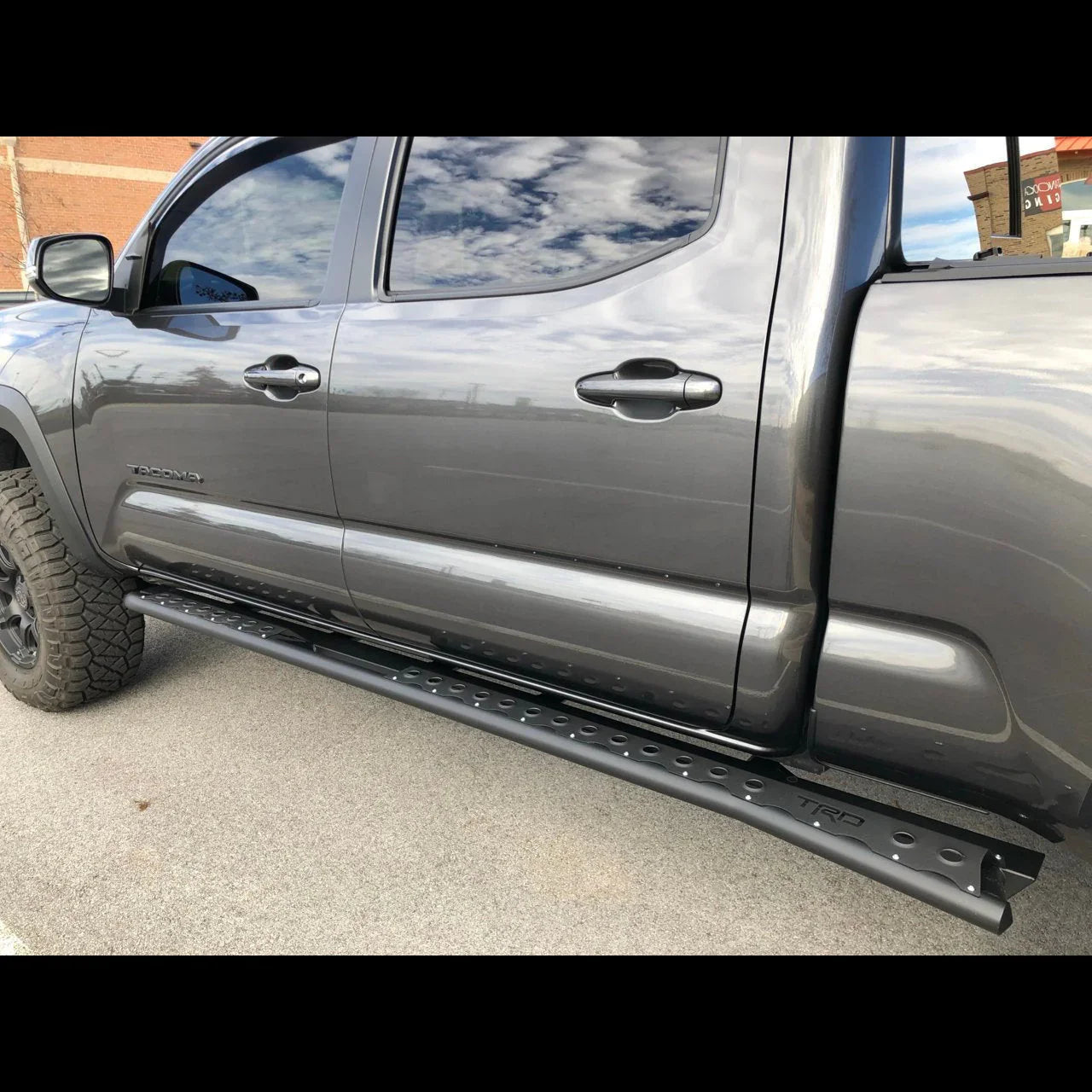 Toyota Tacoma with black TRD rock sliders and off-road tires parked outdoors
