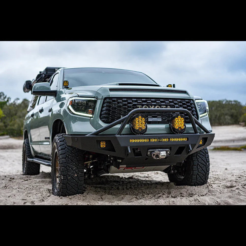 Toyota Tundra equipped with off-road front bumper, LED lights, and winch on sandy terrain
