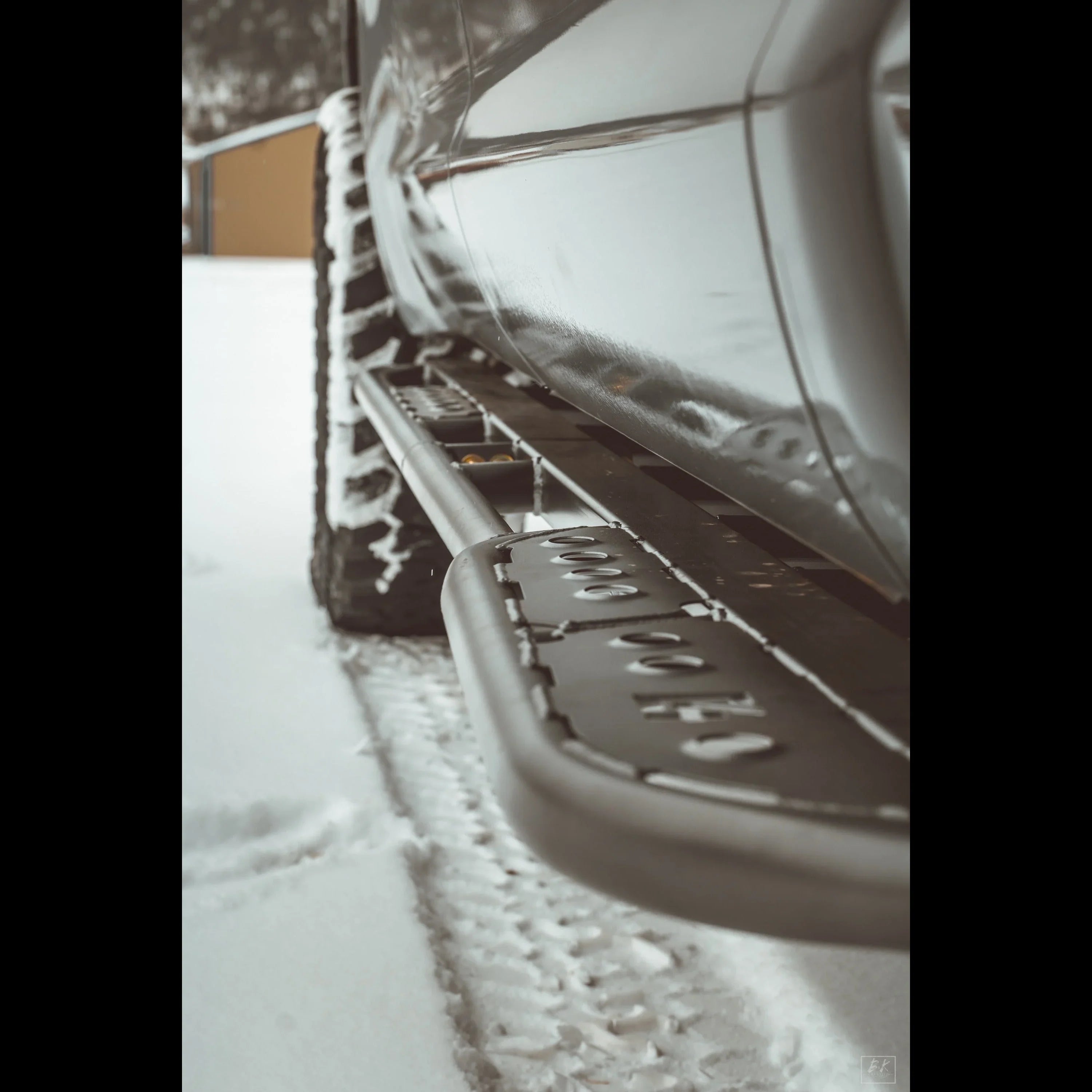Off-road truck with rugged side step rock slider in snowy terrain