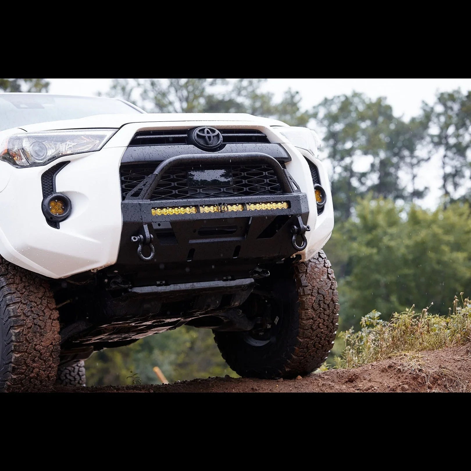 Toyota 4Runner equipped with off-road front bumper, LED light bar, and rugged tires on dirt trail