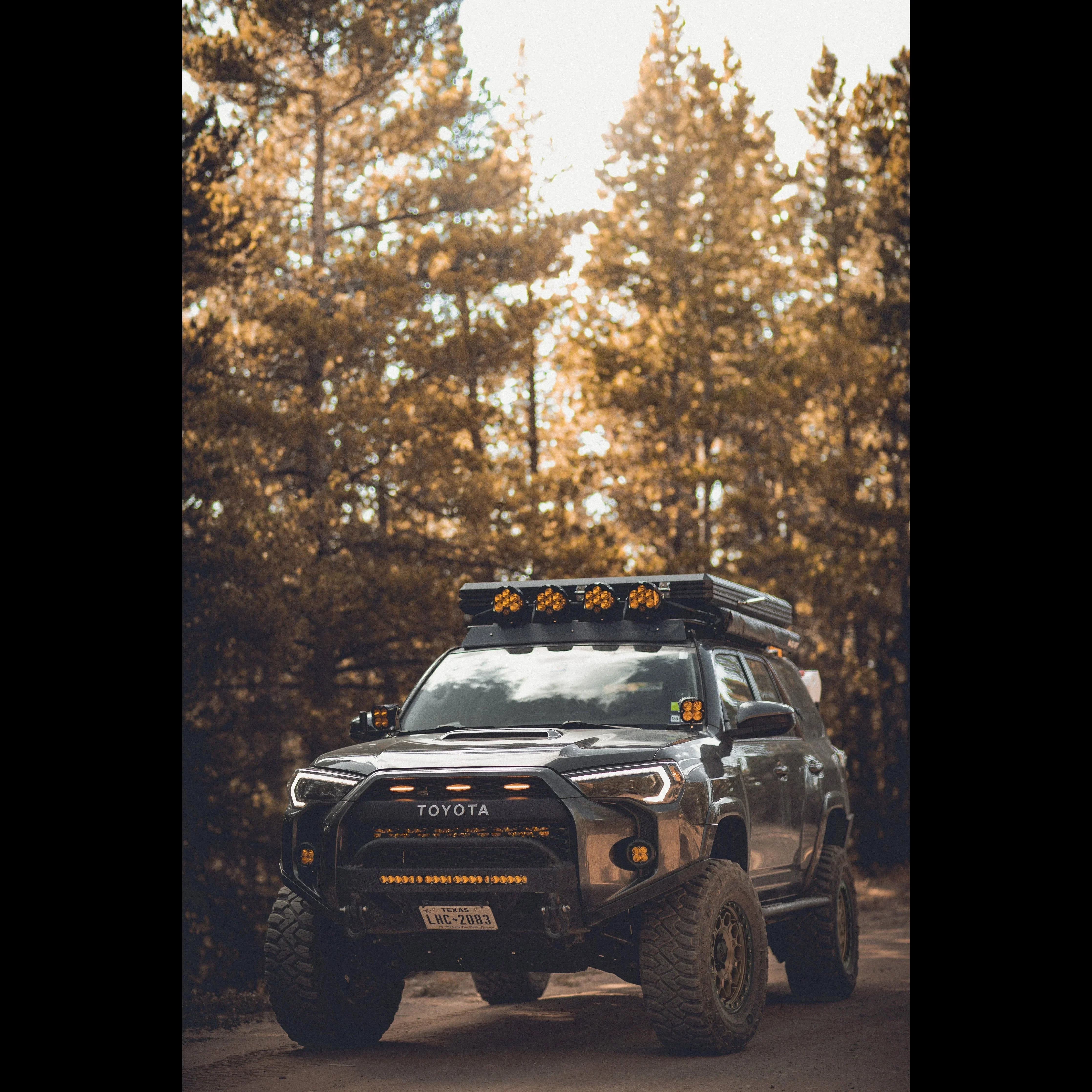 Toyota 4Runner overland SUV with roof rack and off-road gear on a forest trail