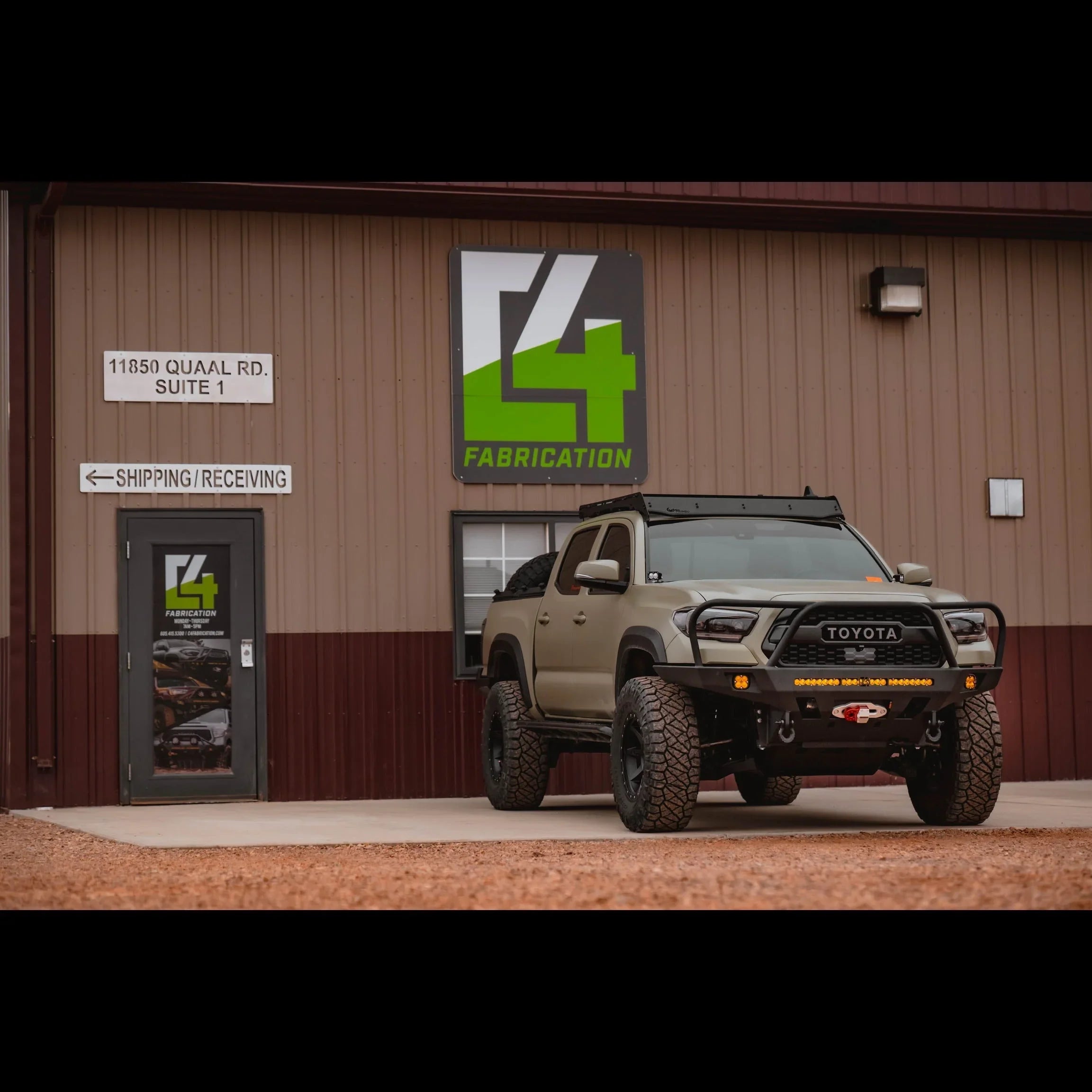 Toyota Tacoma 3rd Gen with overland front bumper parked outside fabrication shop