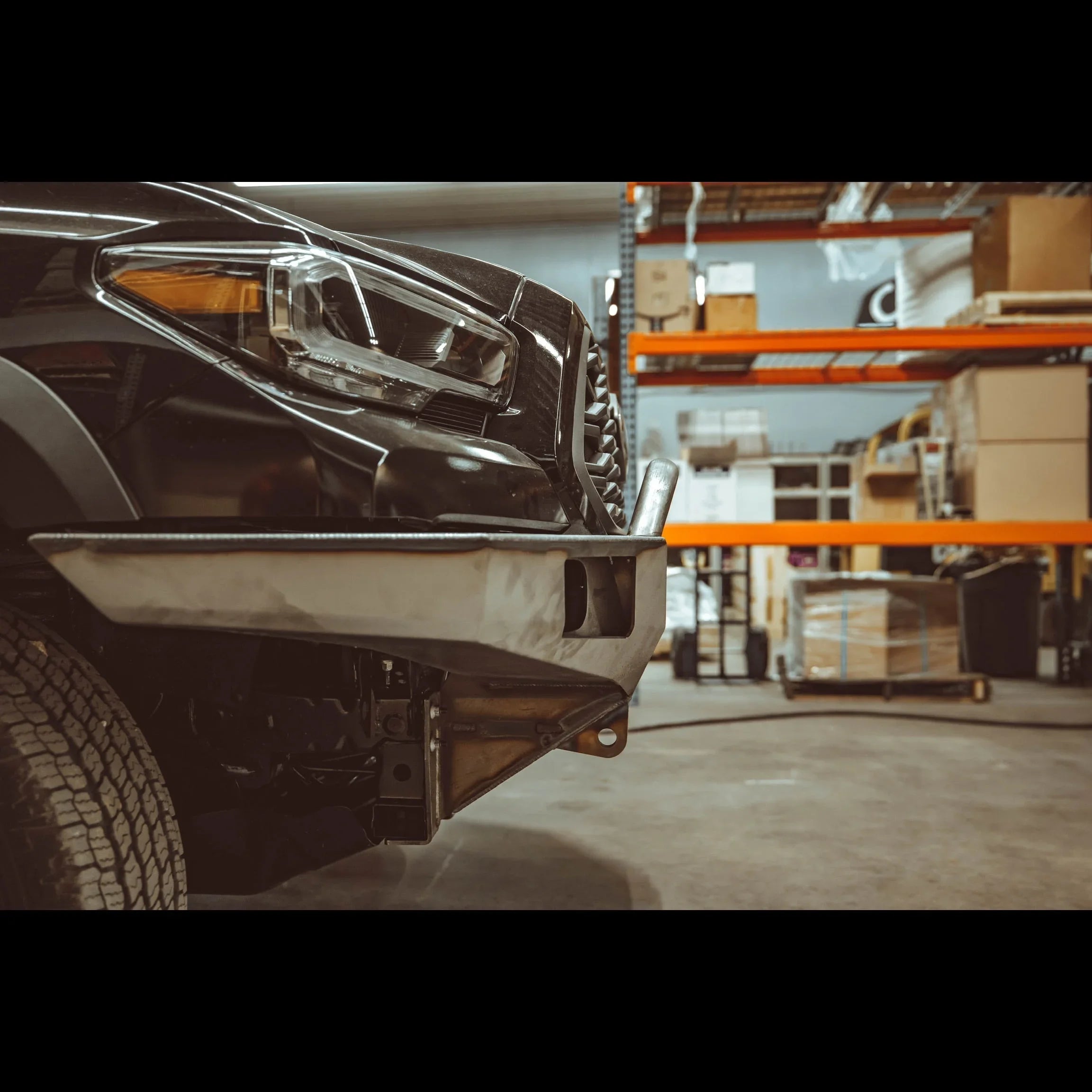 Steel overland front bumper installed on 2016-2022 Toyota Tacoma in warehouse