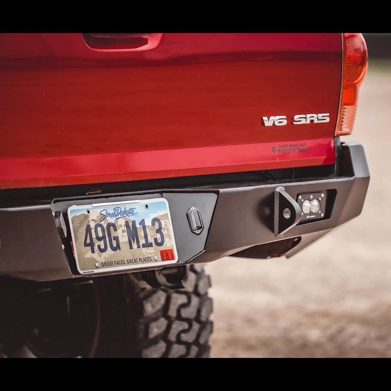 Steel overland rear bumper installed on a red Toyota Tacoma V6 SR5, second generation