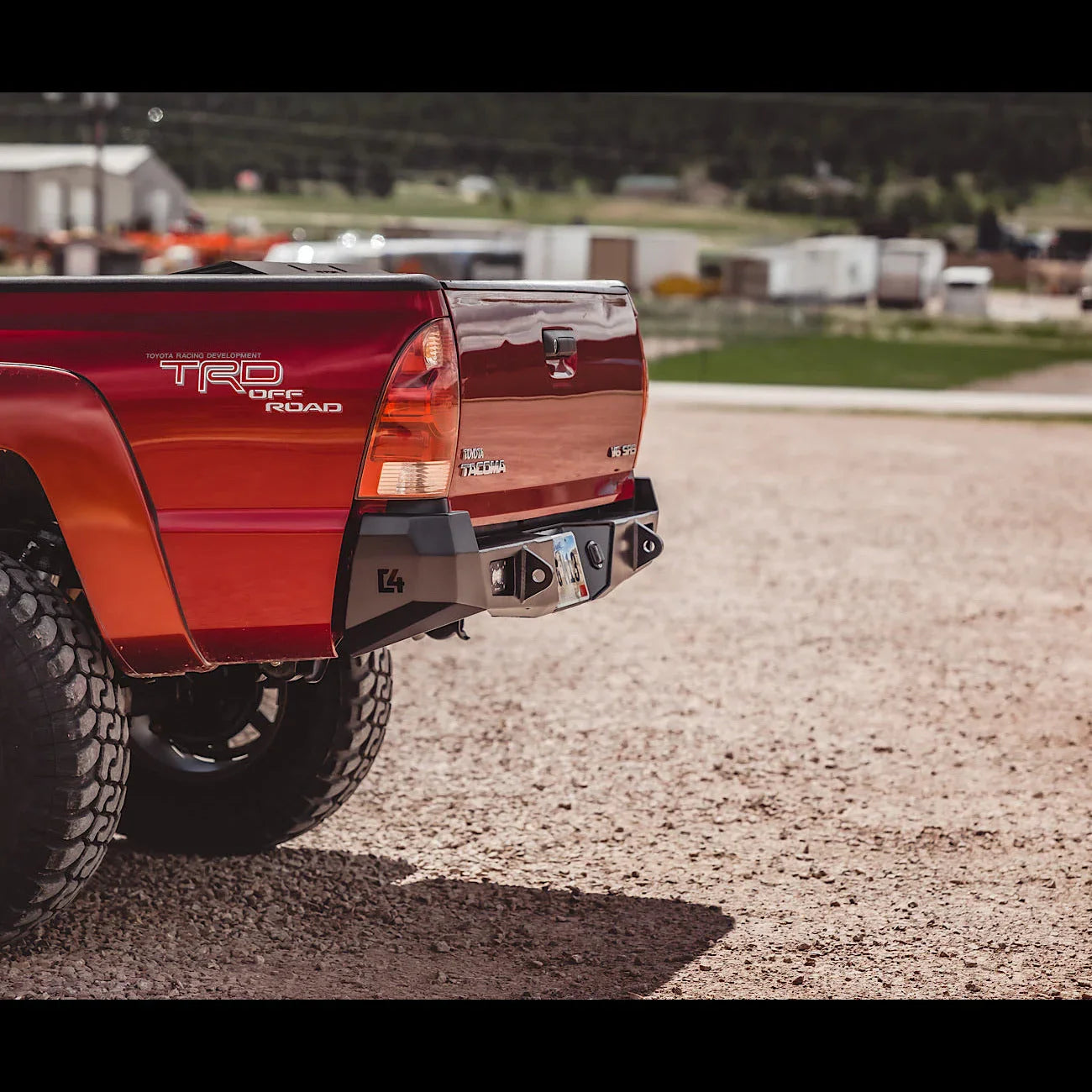 Toyota Tacoma 2nd Gen with heavy-duty overland rear bumper on gravel road