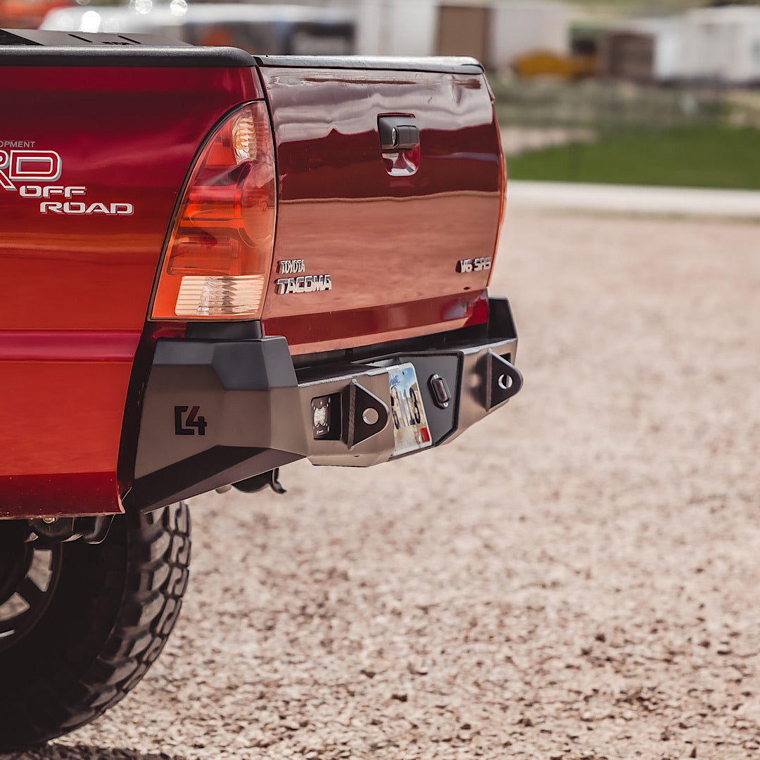 Steel overland rear bumper on red Toyota Tacoma TRD Off Road, 2nd gen, outdoor setting