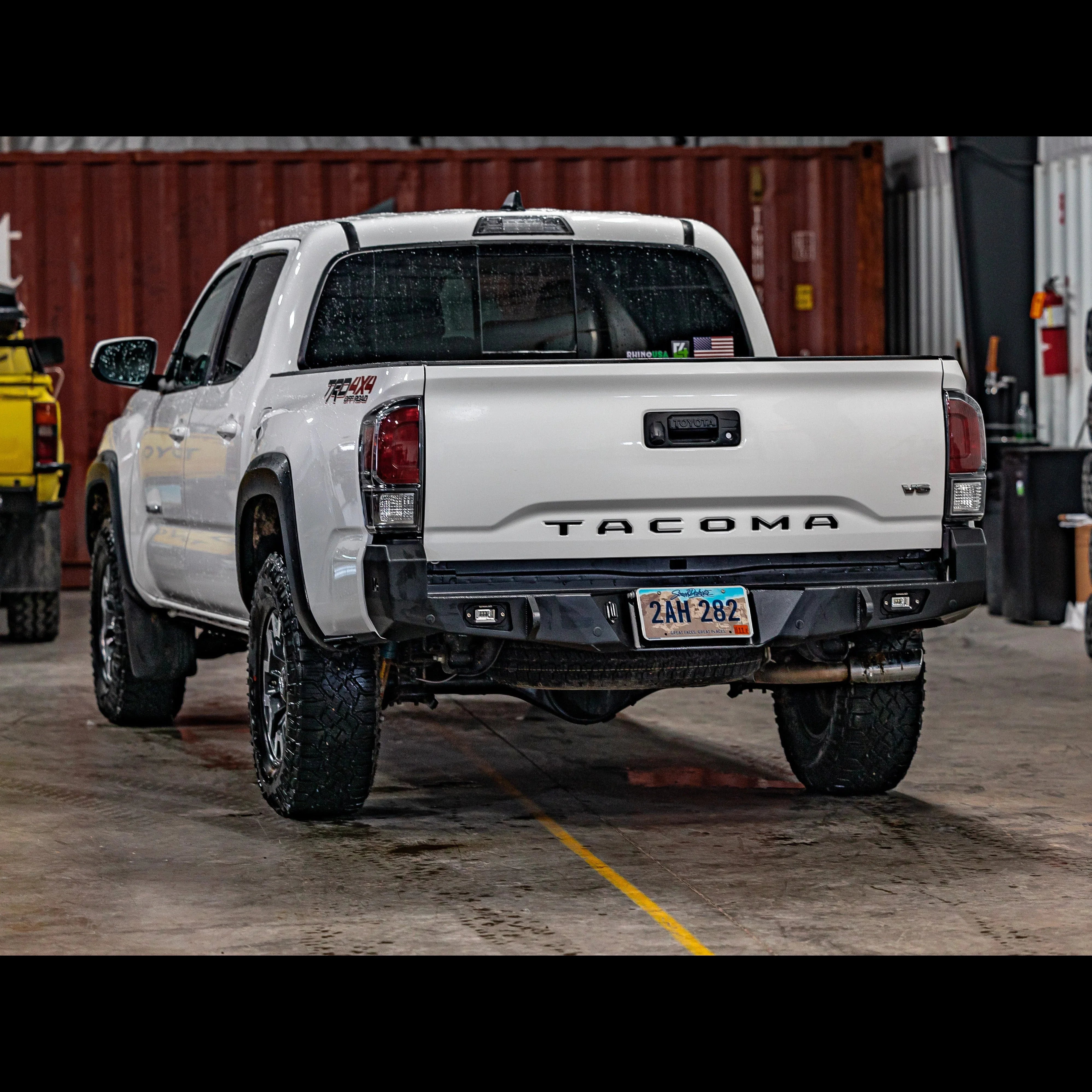 Toyota Tacoma 3rd Gen with aftermarket overland rear bumper in garage setting
