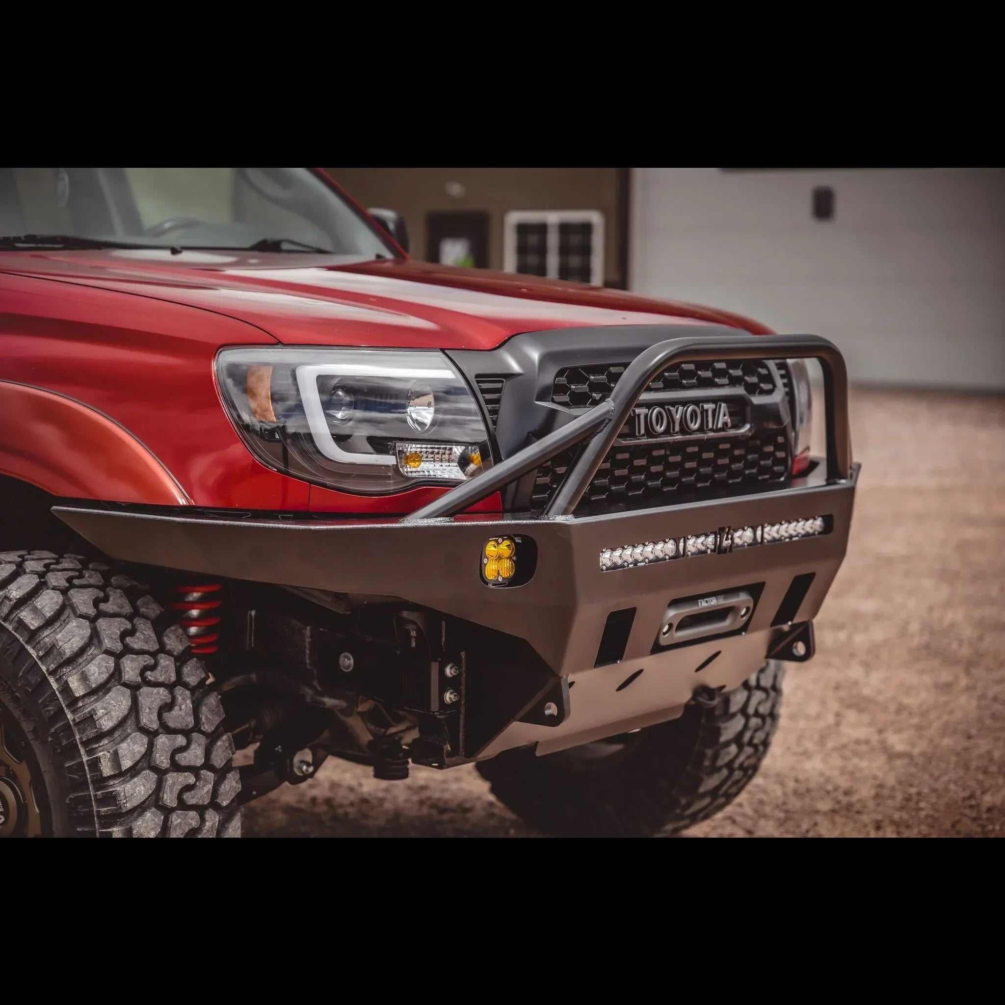 Overland front bumper with LED lights on red Toyota Tacoma 2005-2015, off-road ready.