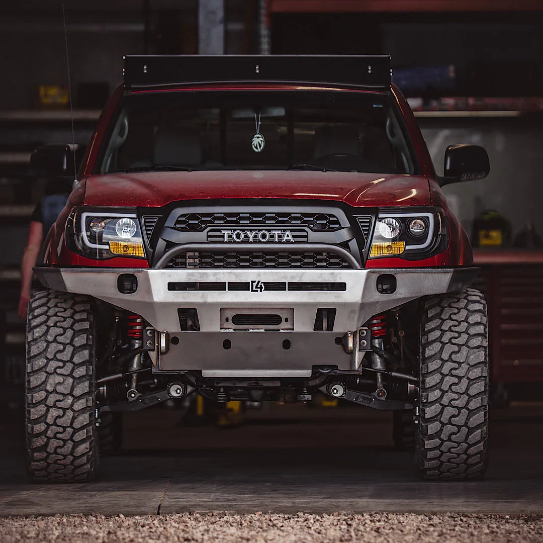 Toyota Tacoma overland front bumper with skid plate, off-road tires, garage setting