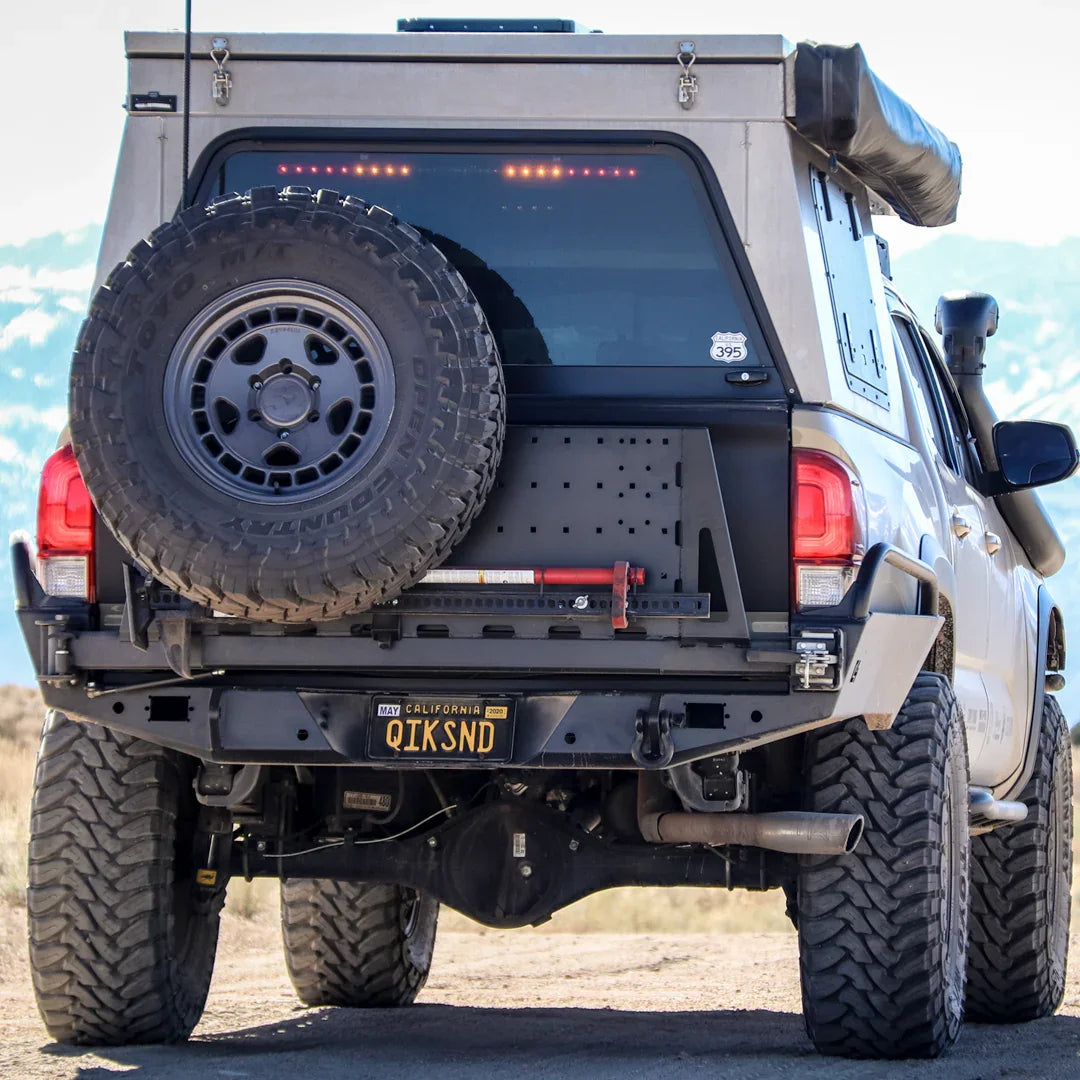 Toyota Tacoma with high clearance rear bumper, spare tire, overland gear, off-road setting