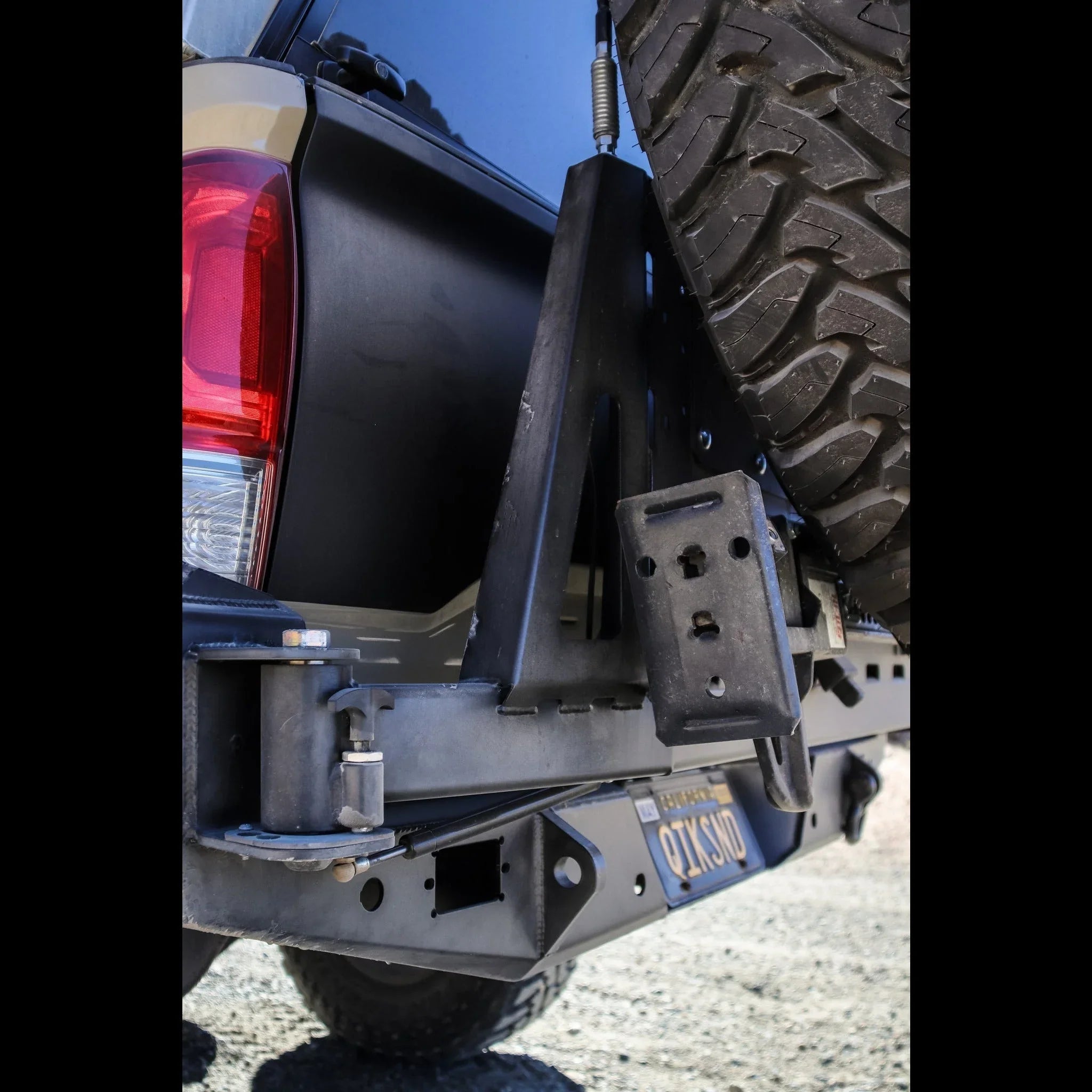 High clearance rear bumper with tire carrier on a Toyota Tacoma overland vehicle