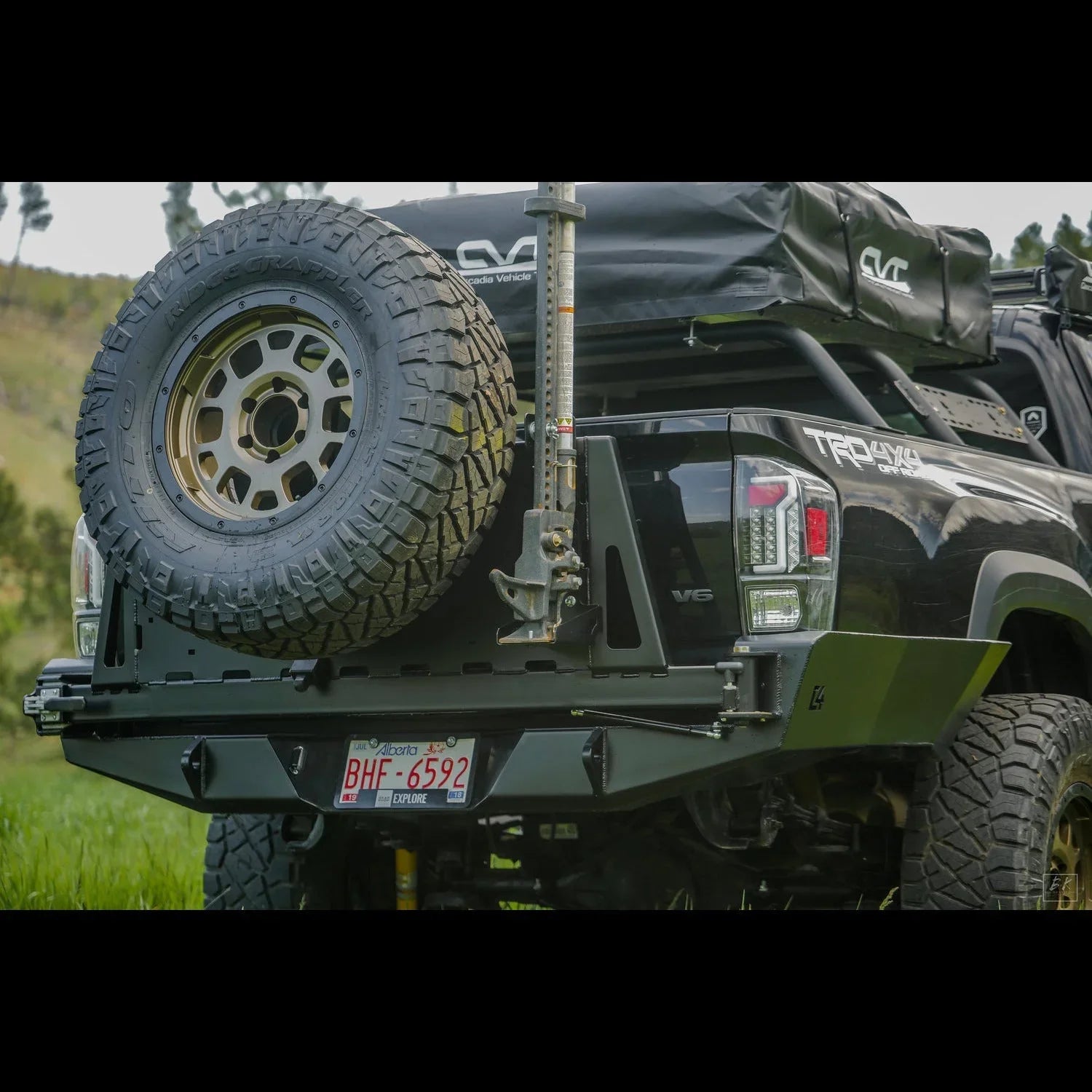 Toyota Tacoma with high clearance overland rear bumper, spare tire, and camping gear rack