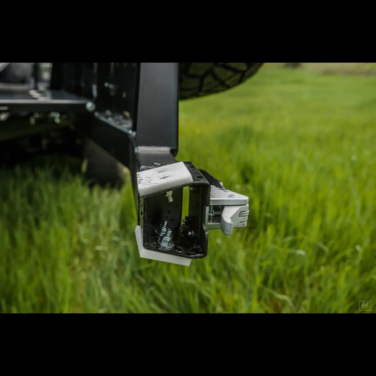 High clearance rear bumper detail for Toyota Tacoma overland truck in grassy field