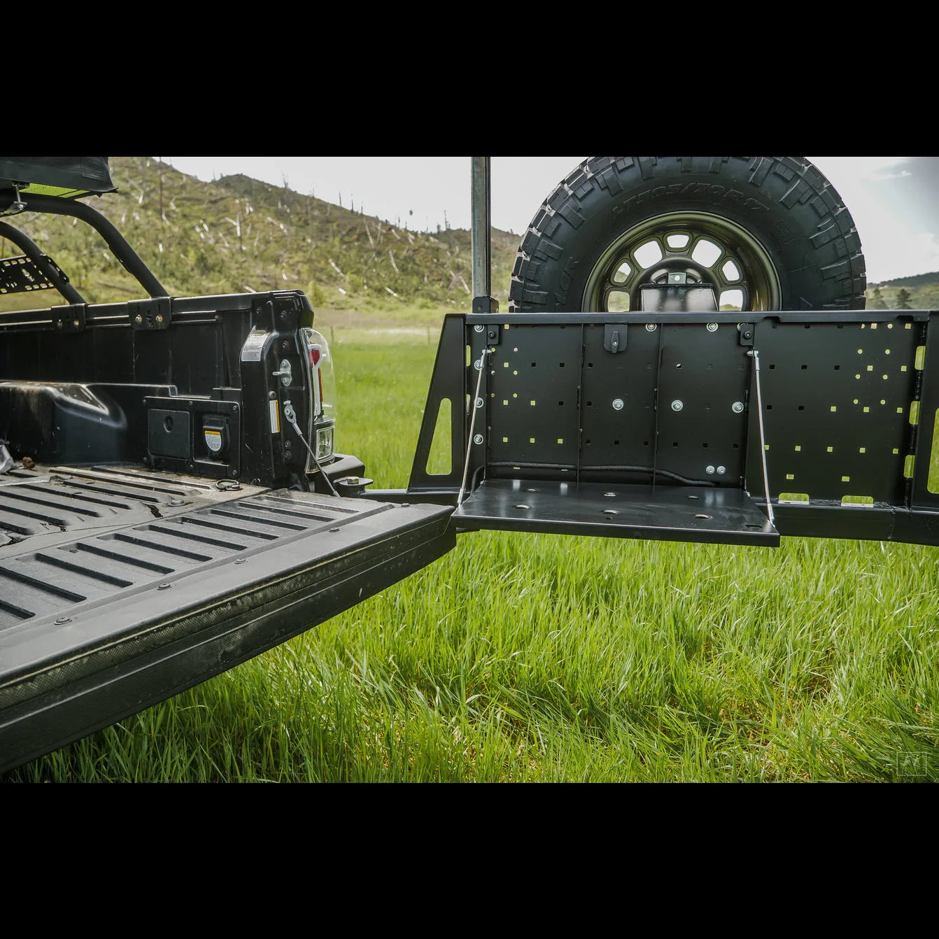 Toyota Tacoma high clearance rear bumper with tire carrier and fold-down table outdoors