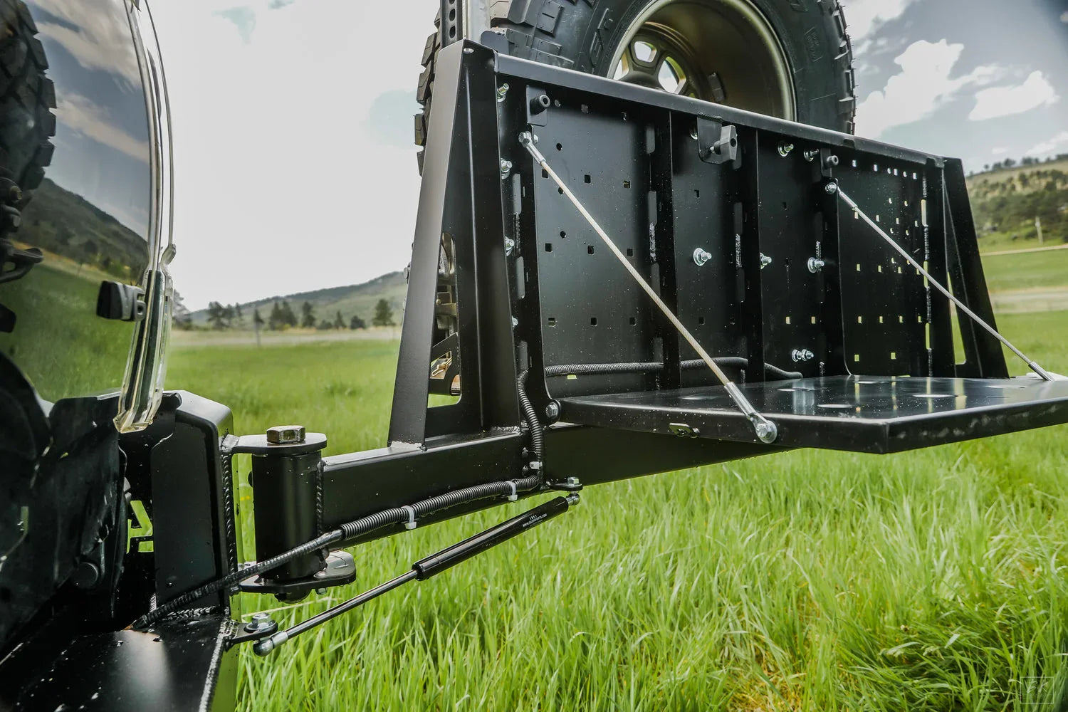 High clearance rear bumper and tire carrier for Toyota Tacoma 3rd gen in grassy field