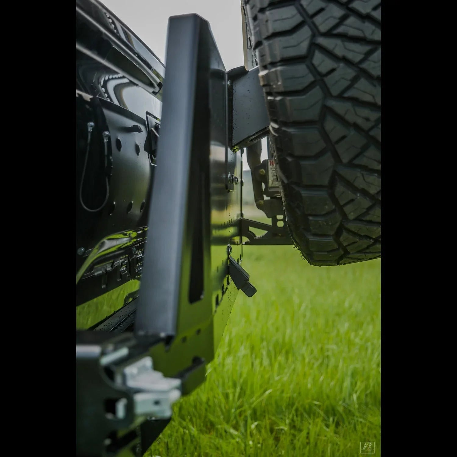 Toyota Tacoma high clearance rear bumper and off-road spare tire on grassy field