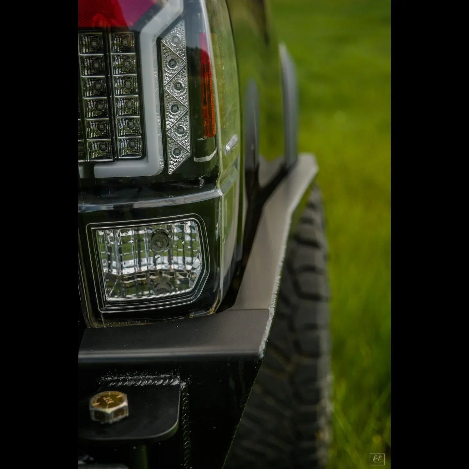 Toyota Tacoma rear bumper high clearance close-up with aftermarket taillight and off-road tire