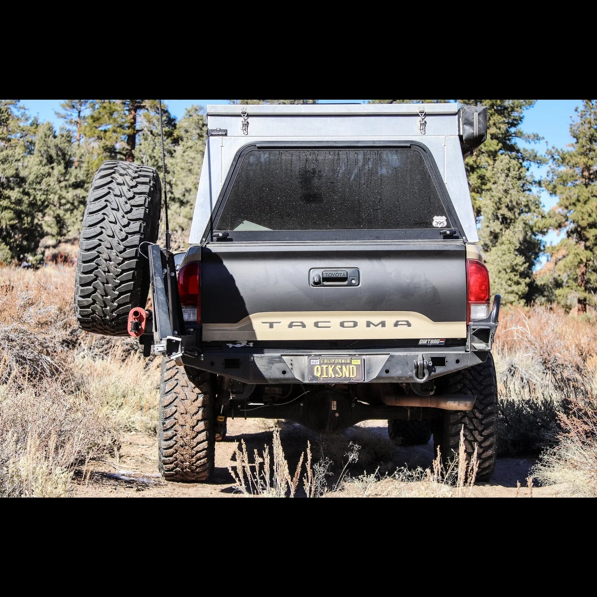 Toyota Tacoma with high clearance rear bumper and spare tire carrier on an off-road trail