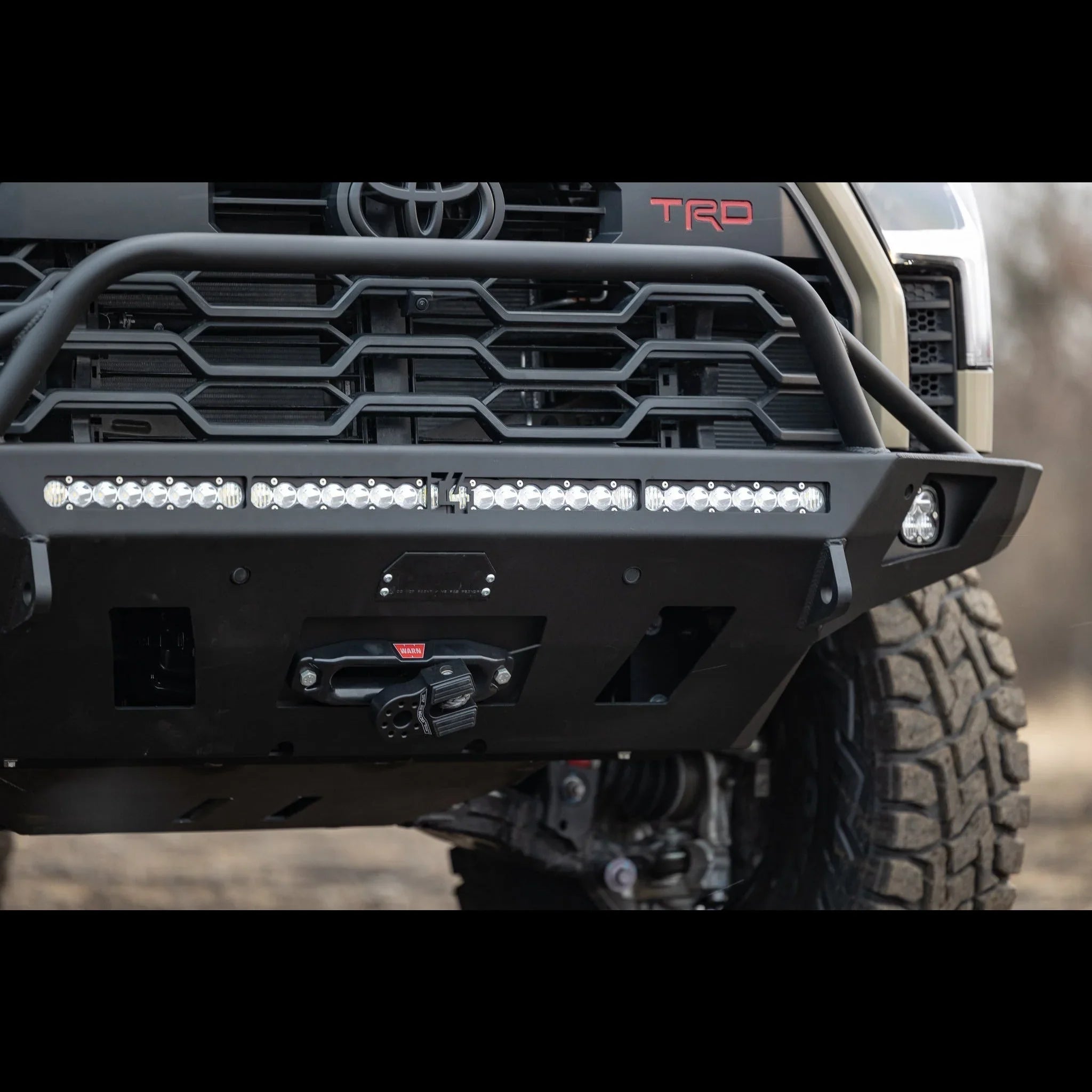 Toyota Tundra front bumper with off-road LED light bar and winch, close-up view