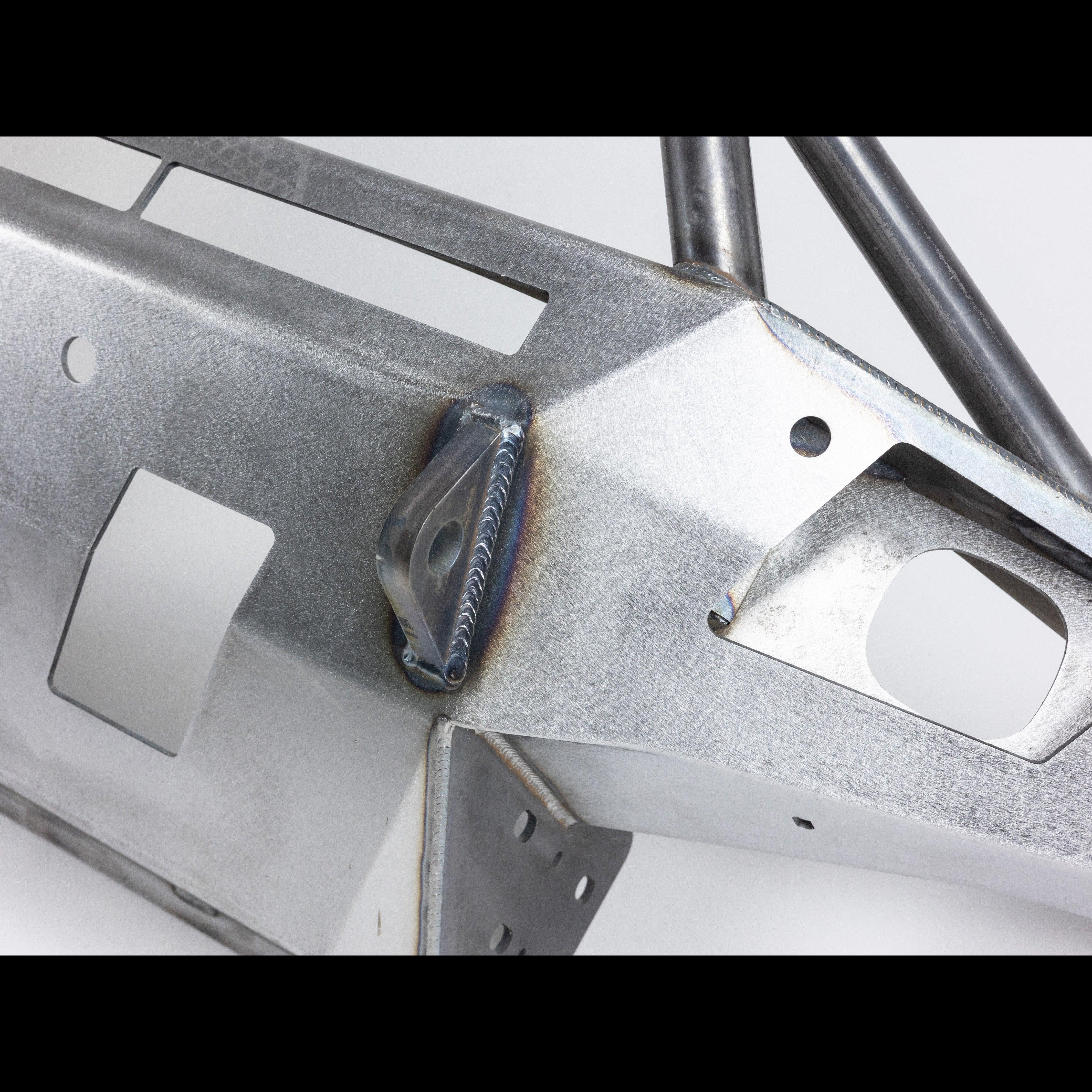 Closeup of heavy-duty steel front bumper with welds and cutouts for Toyota Tundra overlanding.
