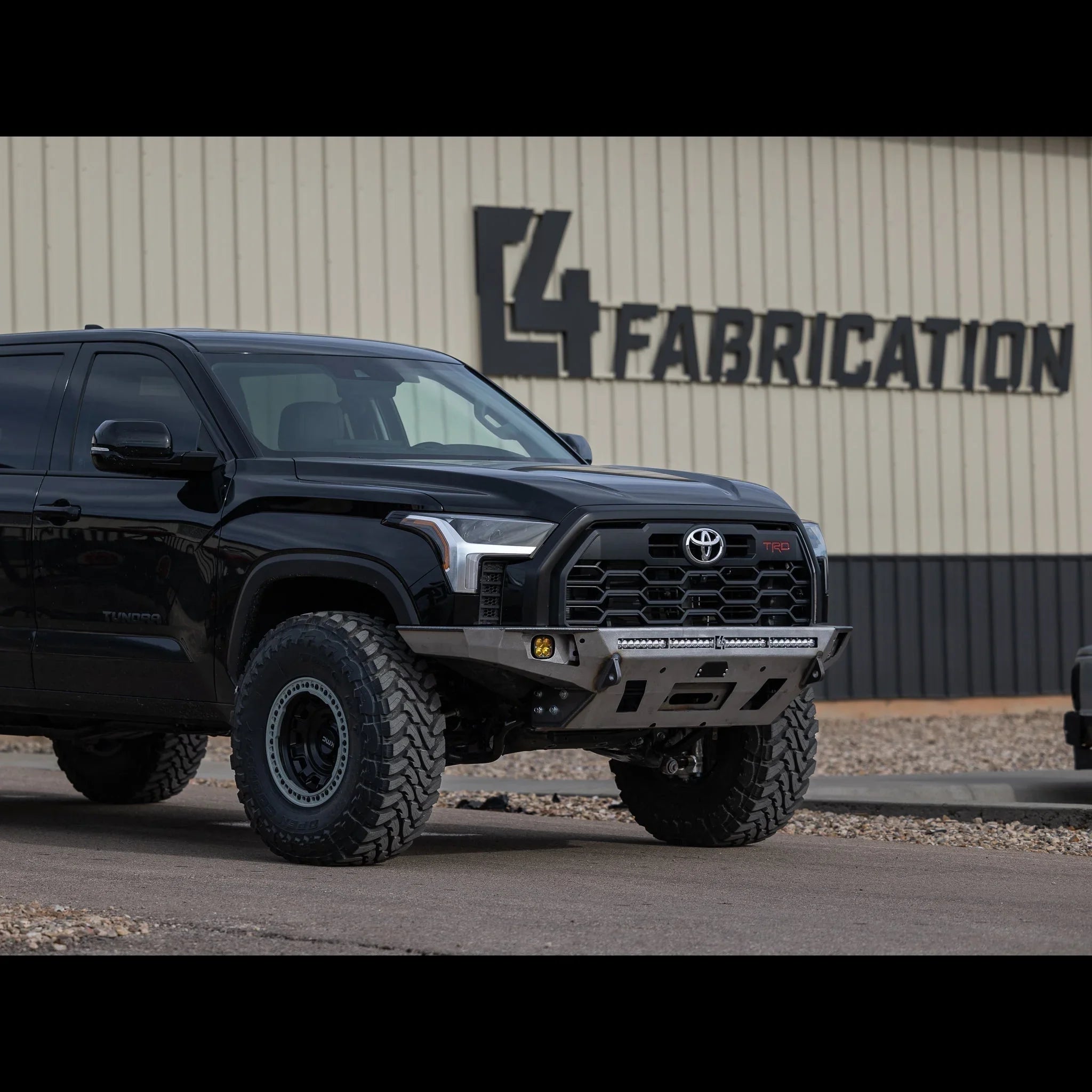 Toyota Tundra 3rd Gen with off-road front bumper, LED lights, and rugged tires outdoors