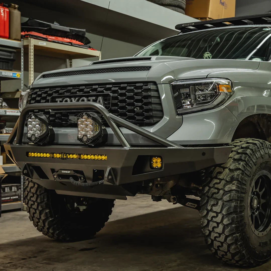 Toyota Tundra front view with off-road bumper, LED lights, and rugged tires in a garage