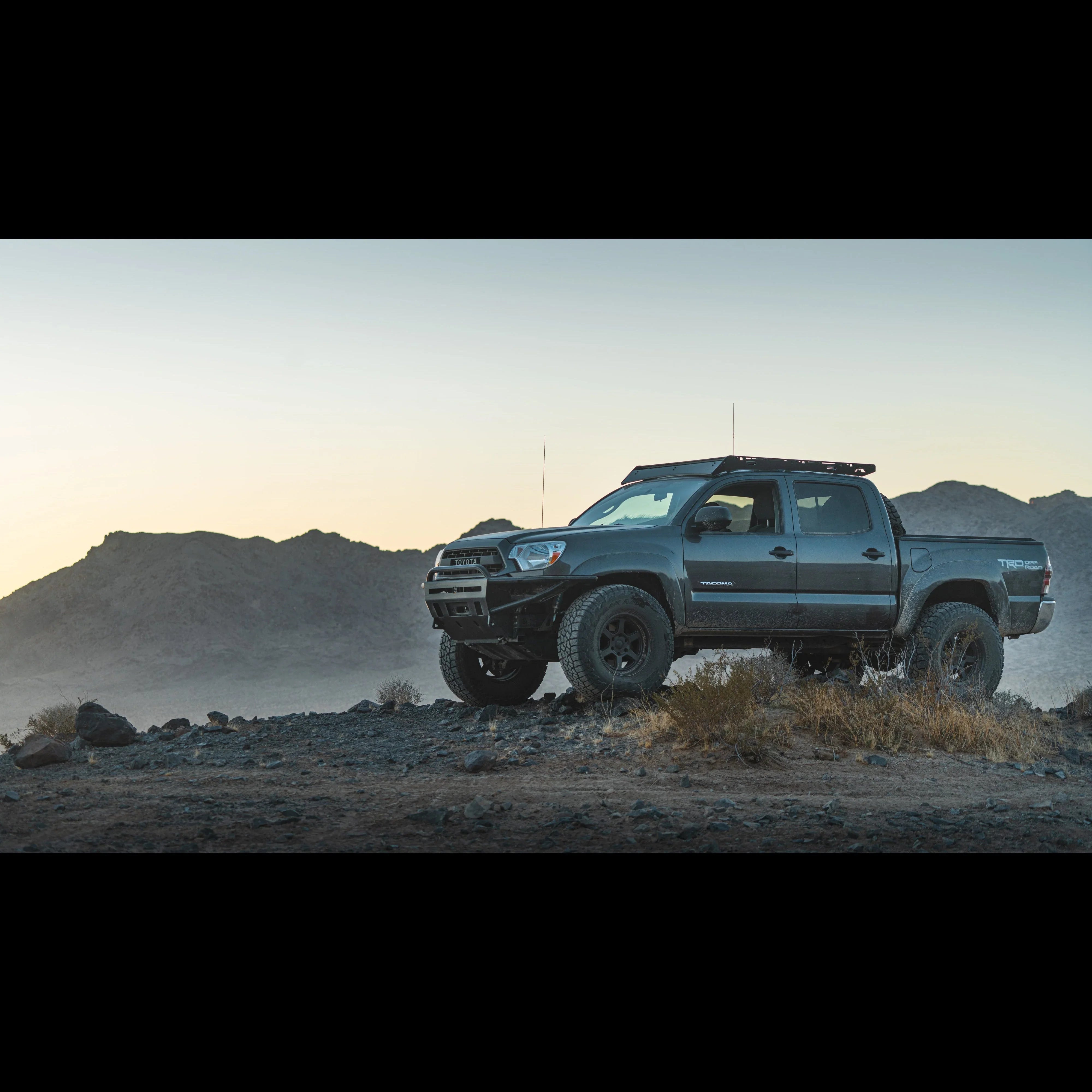 Toyota Tacoma TRD Off-Road parked on rocky terrain at sunrise, overlanding truck