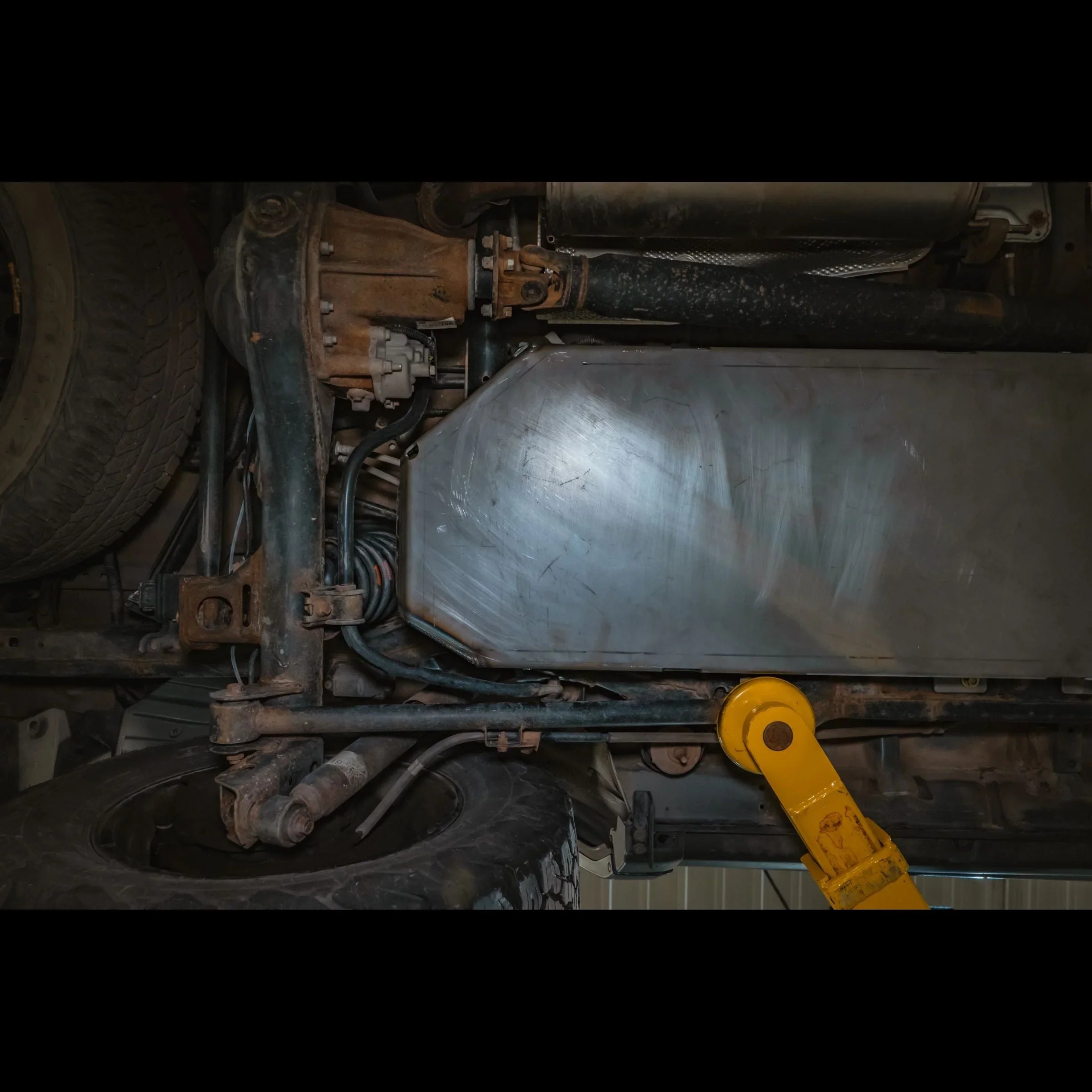 Heavy duty gas tank skid plate installed under off-road vehicle for undercarriage protection