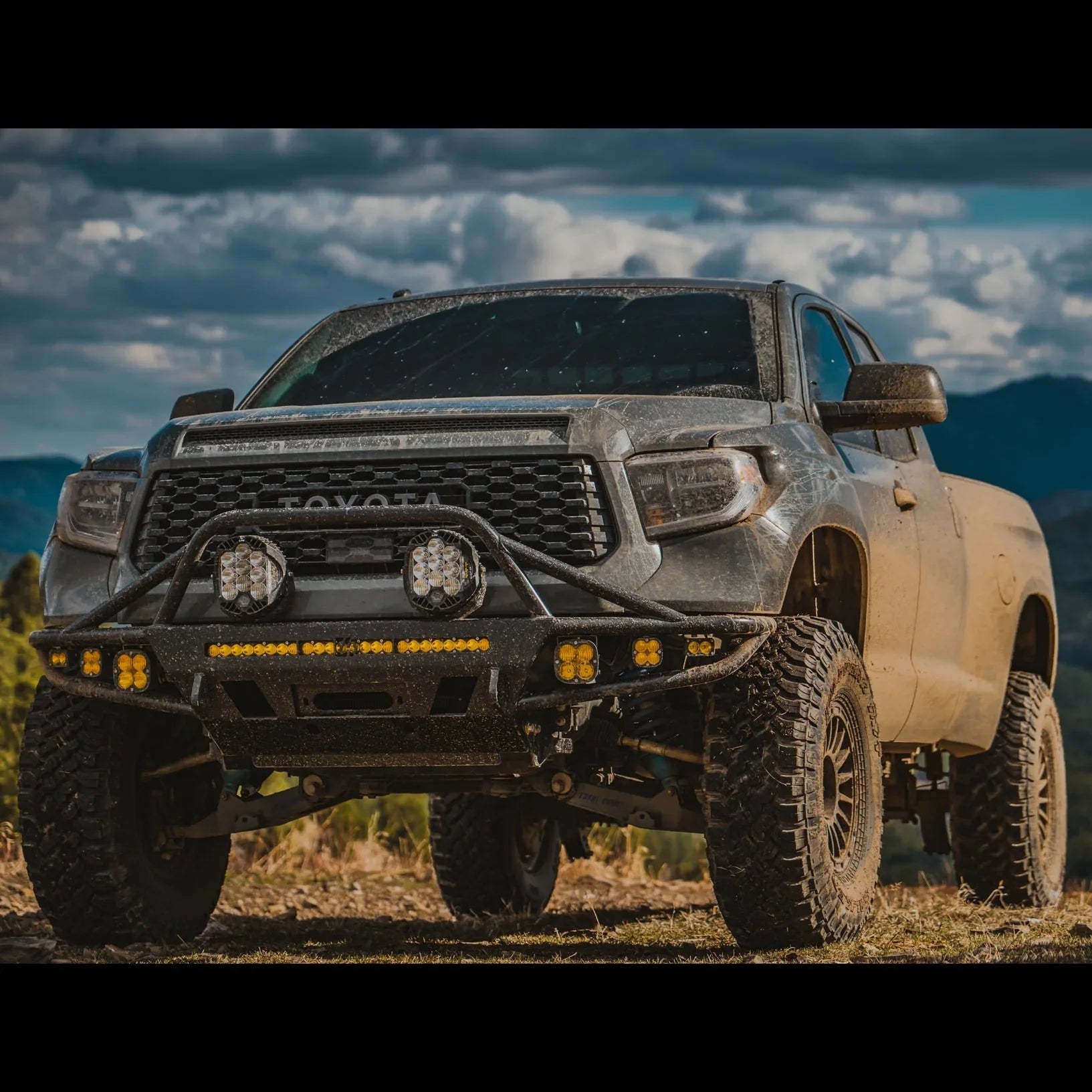 Toyota Tundra overland truck with off-road bumper, LED lights, and rugged tires on a trail