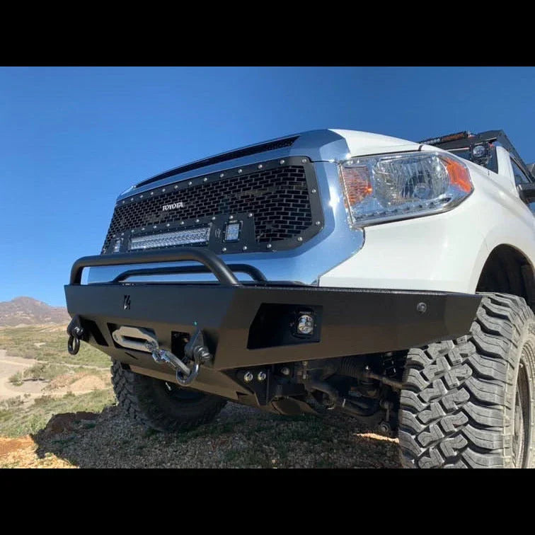 Toyota Tundra with aftermarket off-road front bumper and winch on rugged terrain