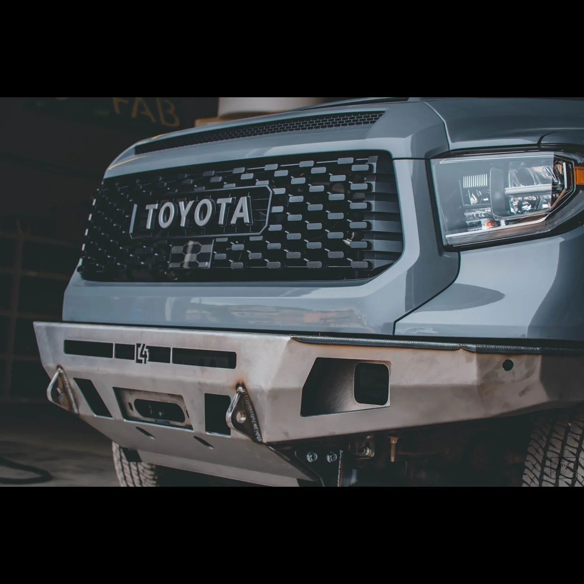 Toyota truck front with aftermarket grille and heavy-duty steel bumper for overlanding