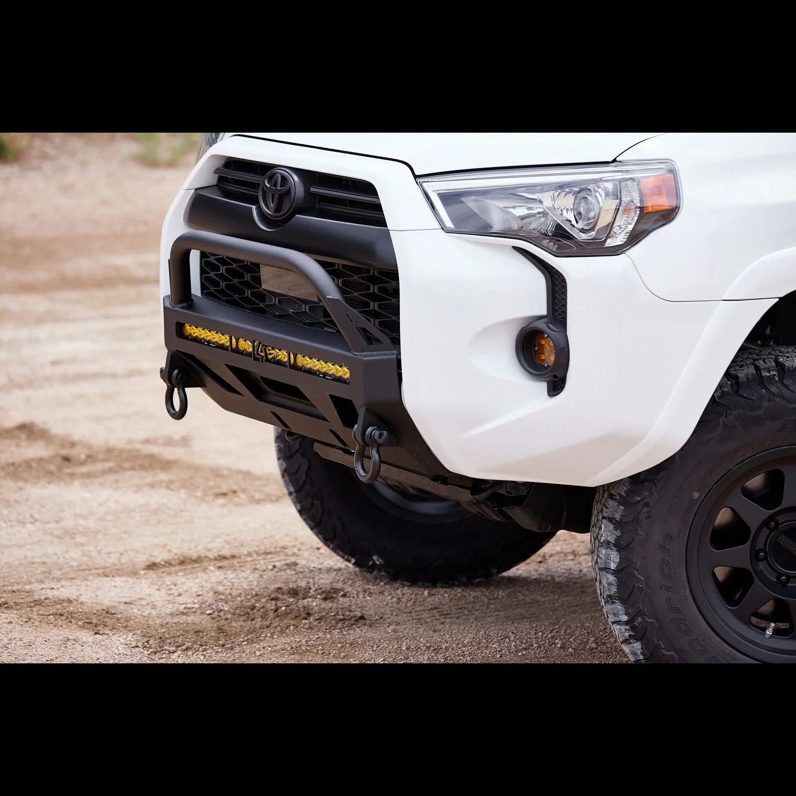 Toyota 4Runner with off-road front bumper, recovery hooks, and LED light bar on rugged terrain