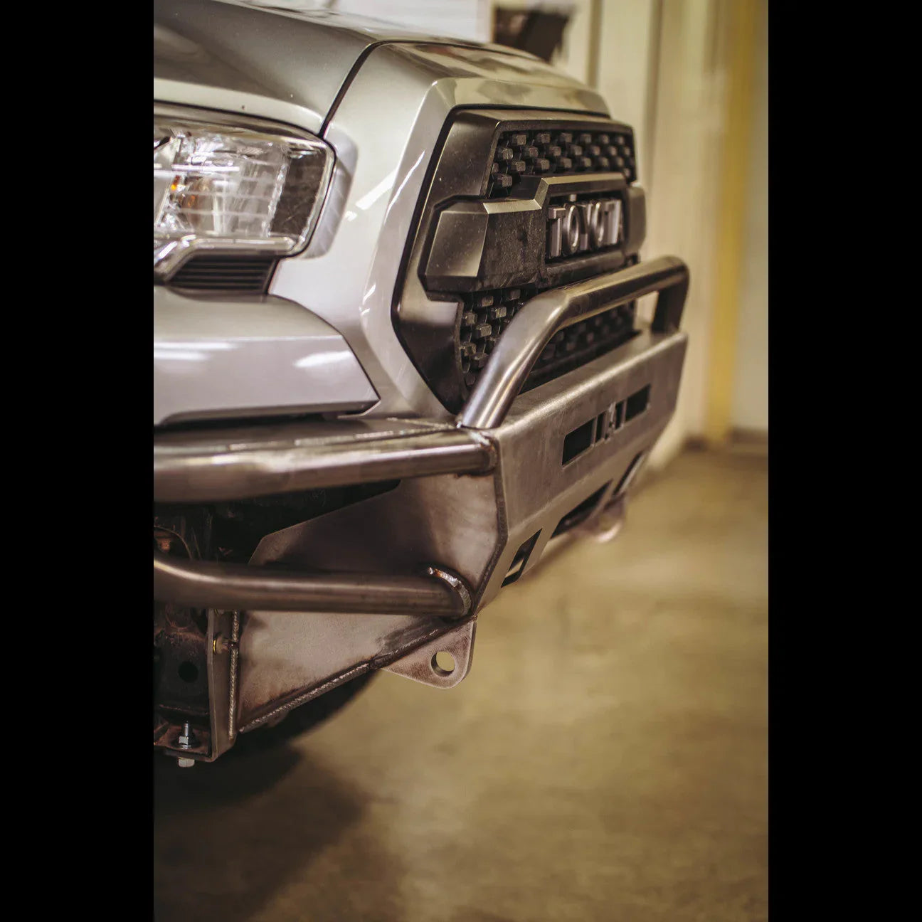 Steel front bumper with grille guard on Toyota Tacoma, overlanding vehicle accessory