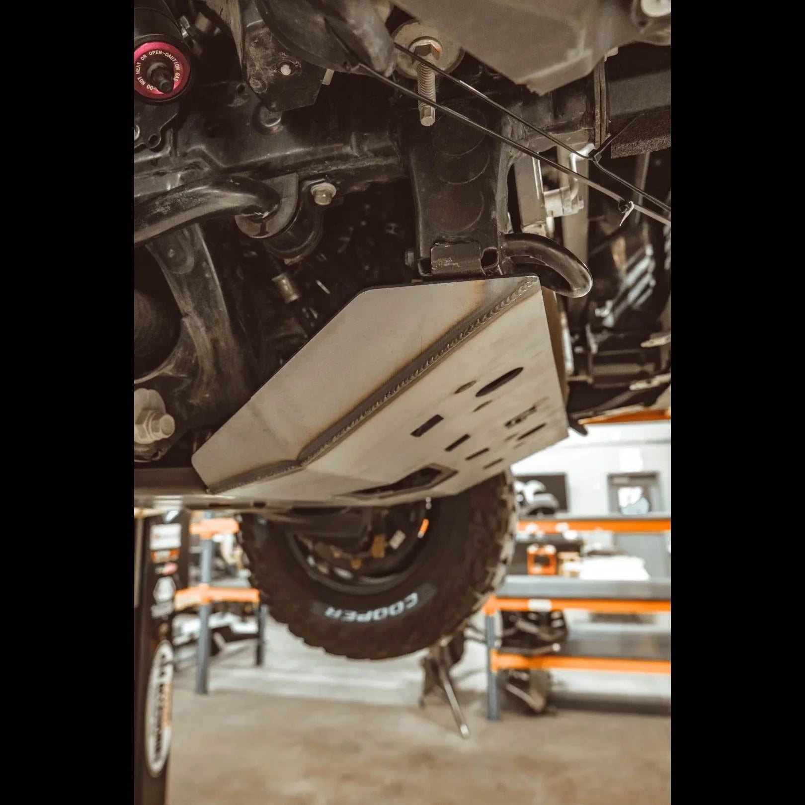 Steel skid plate installed on off-road vehicle undercarriage for overlanding protection