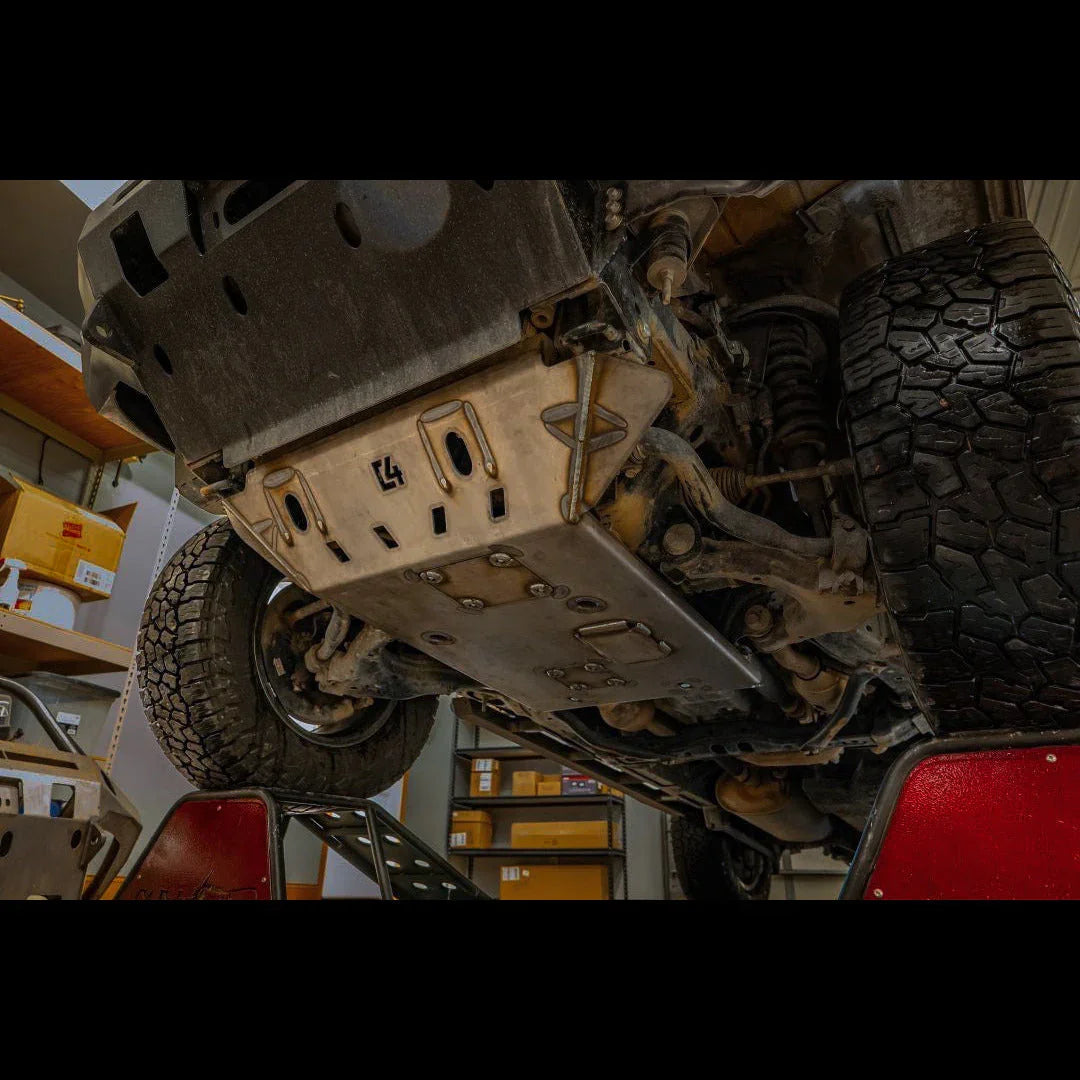 Heavy-duty skid plate installed on off-road vehicle undercarriage in workshop