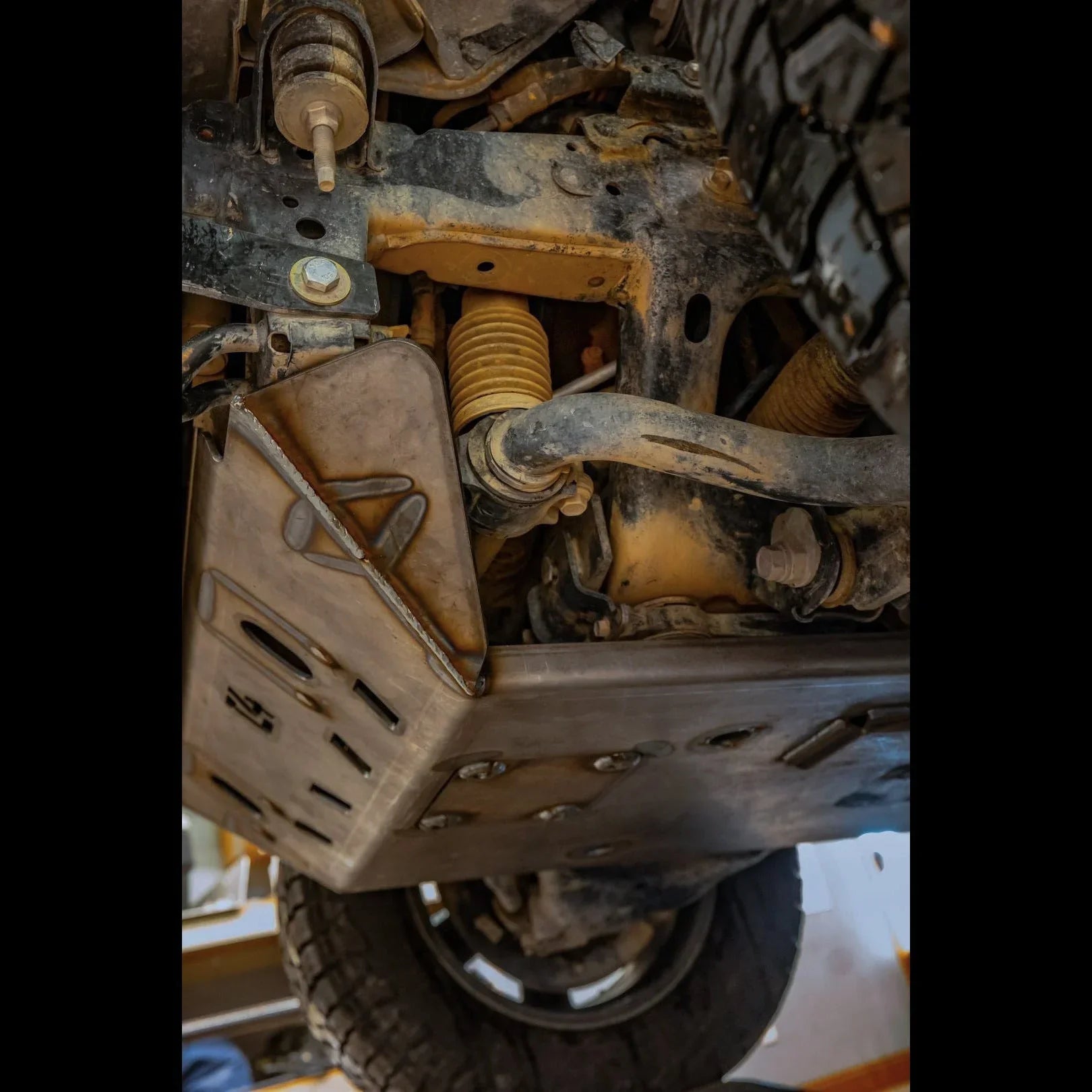 Close-up of an off-road vehicle's heavy-duty metal skid plate protecting suspension components