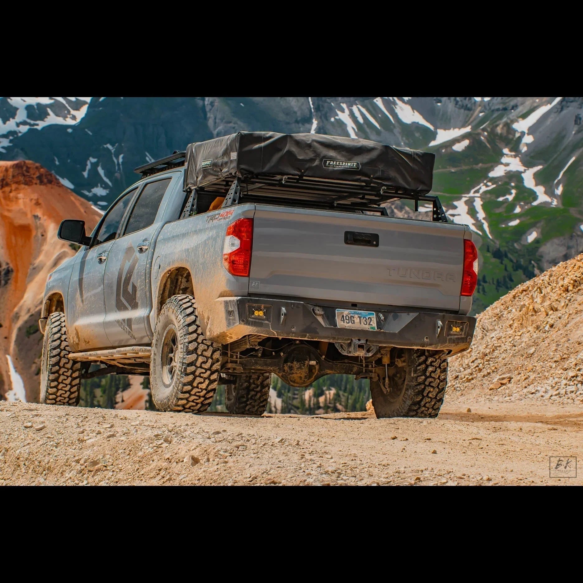 Toyota Tundra TRD Off-Road pickup with rooftop tent on mountain trail, adventure overlanding