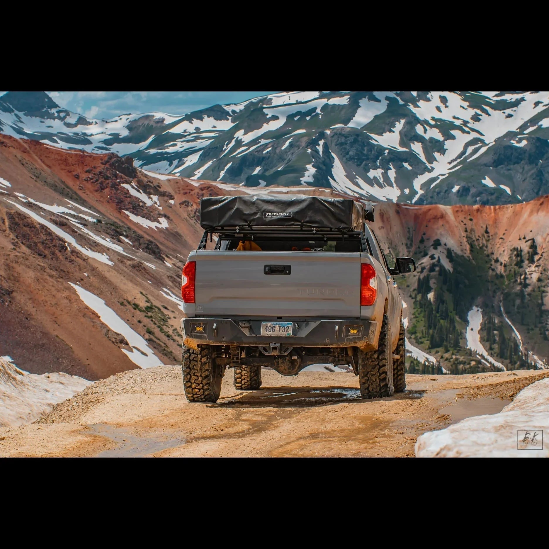 Toyota Tundra with roof rack and camping gear on a rugged mountain trail, overlanding adventure