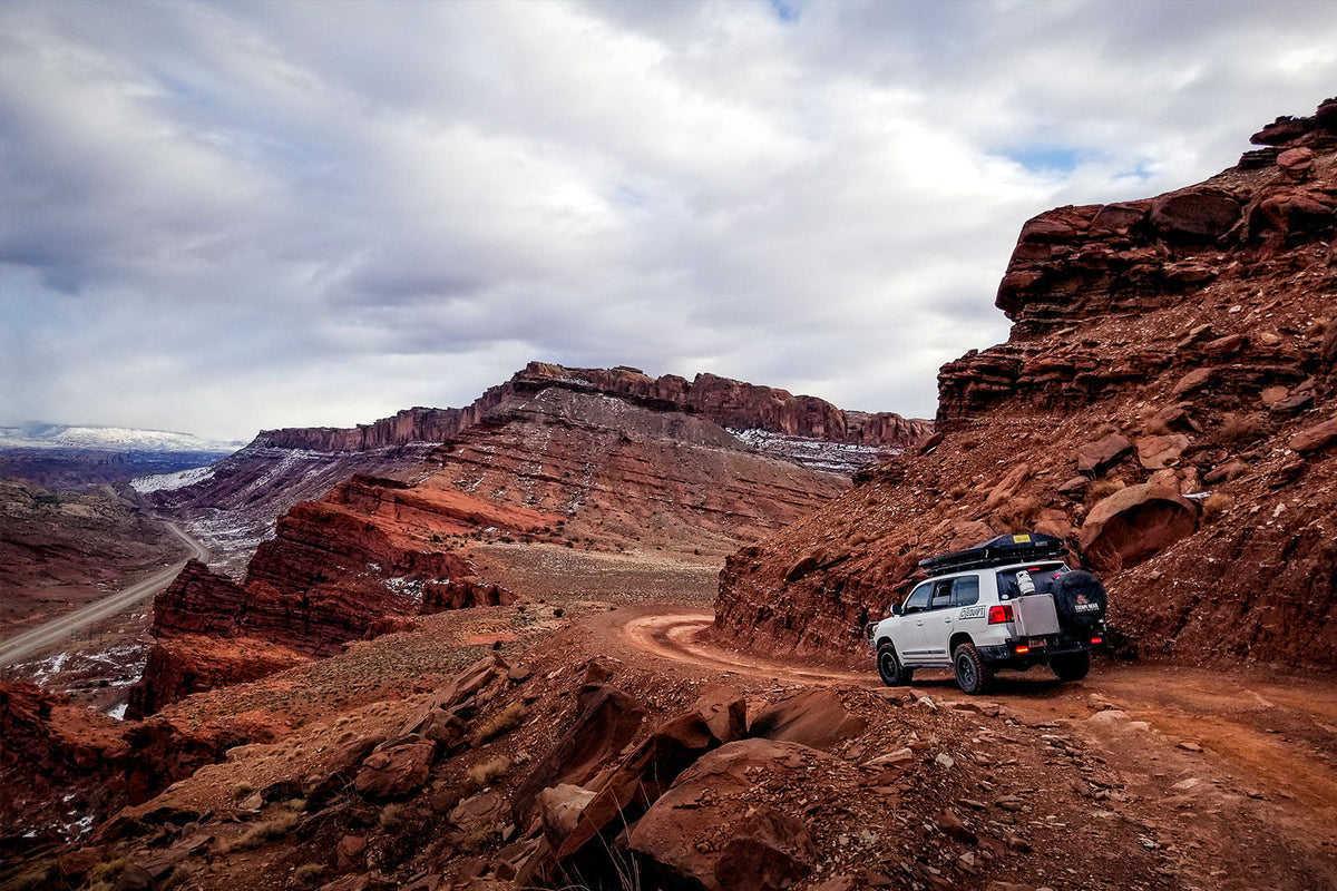 Toyota 4Runner with a full-length low-profile roof rack and light bar fairing on a dirt road