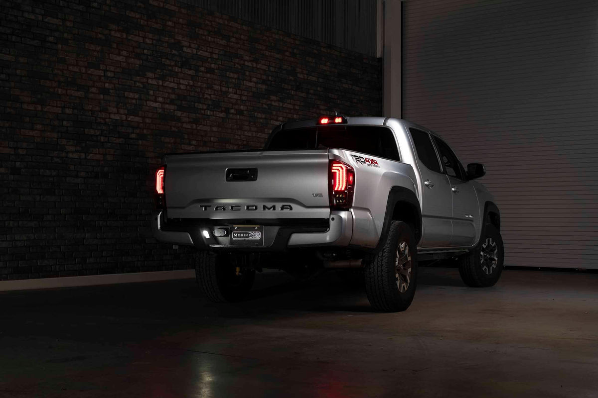 Silver Toyota Tacoma TRD Off-Road pickup with LED tail lights in a dimly lit garage