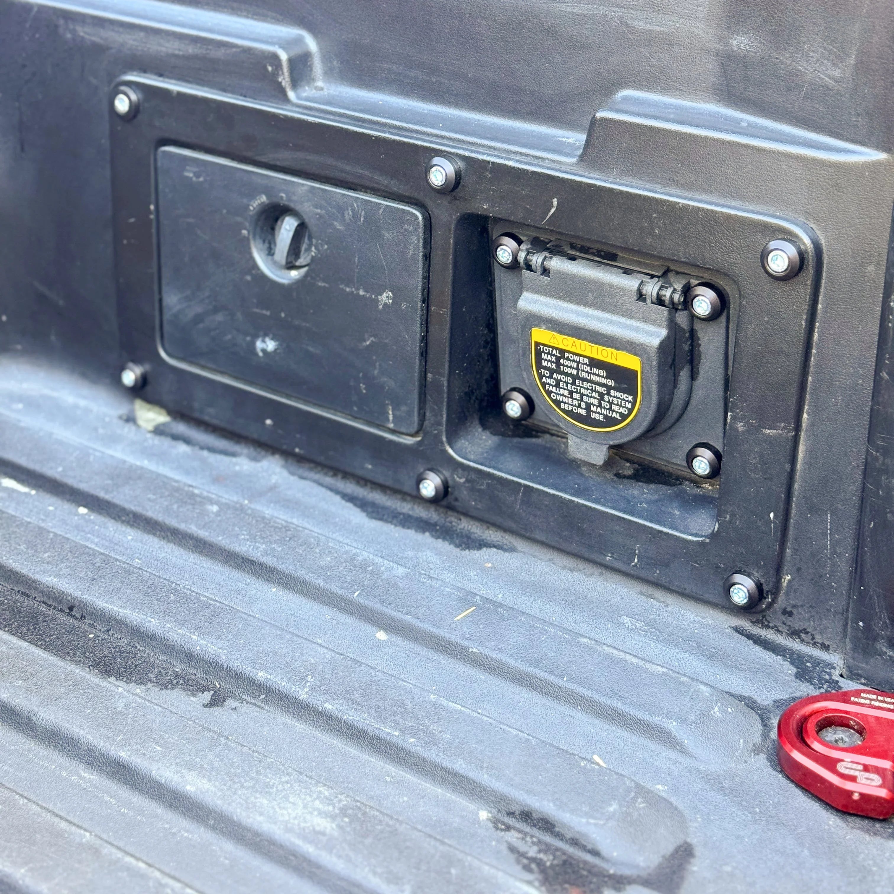 Toyota Tacoma bed power outlet panel with upgraded dress up hardware bolts installed