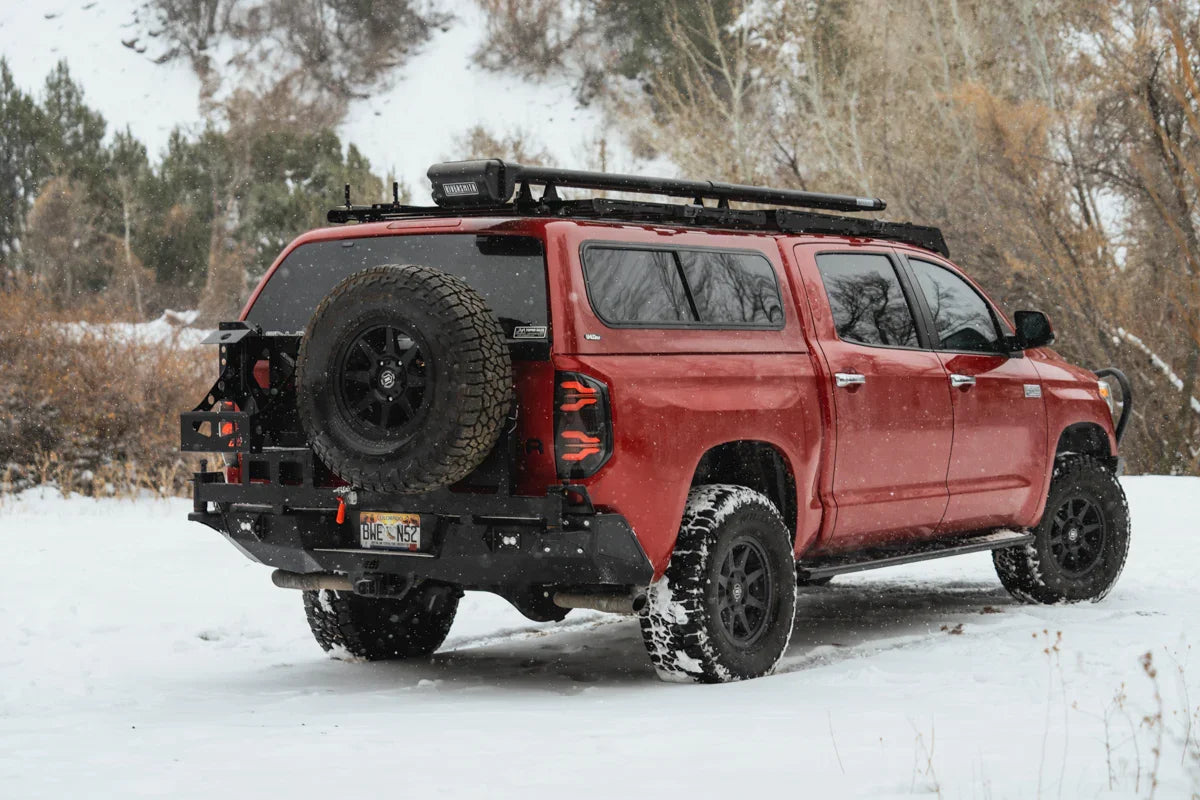 Toyota Tundra with off-road rear bumper and spare tire in snowy outdoor setting