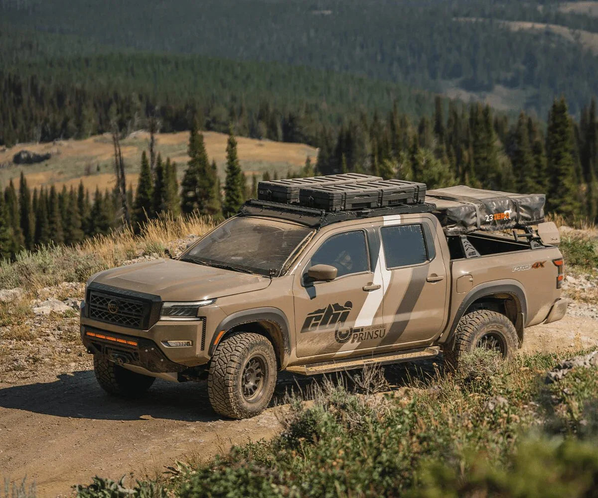 2022 Nissan Frontier with Prinsu roof rack and overlanding gear on a mountain trail