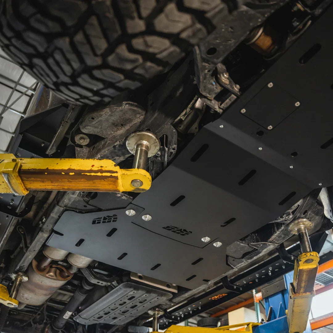 3rd Gen Nissan Frontier rear skid plate installed on vehicle undercarriage, shop setting