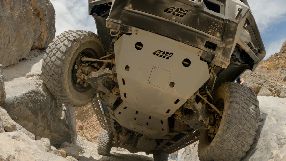 Toyota Tacoma off-road with full skid plates on rocky trail, view from underneath