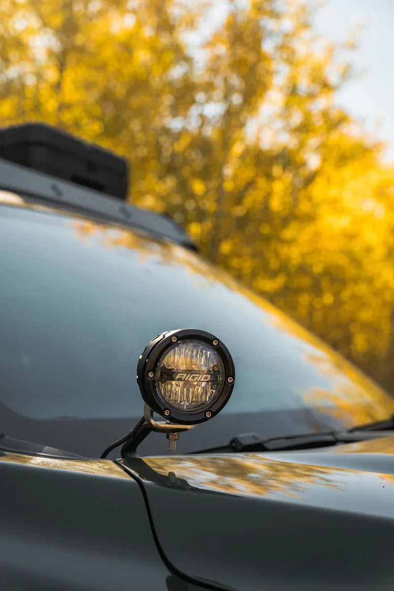Close-up of Rigid off-road LED pod light mounted on Toyota Tundra hood, outdoor setting