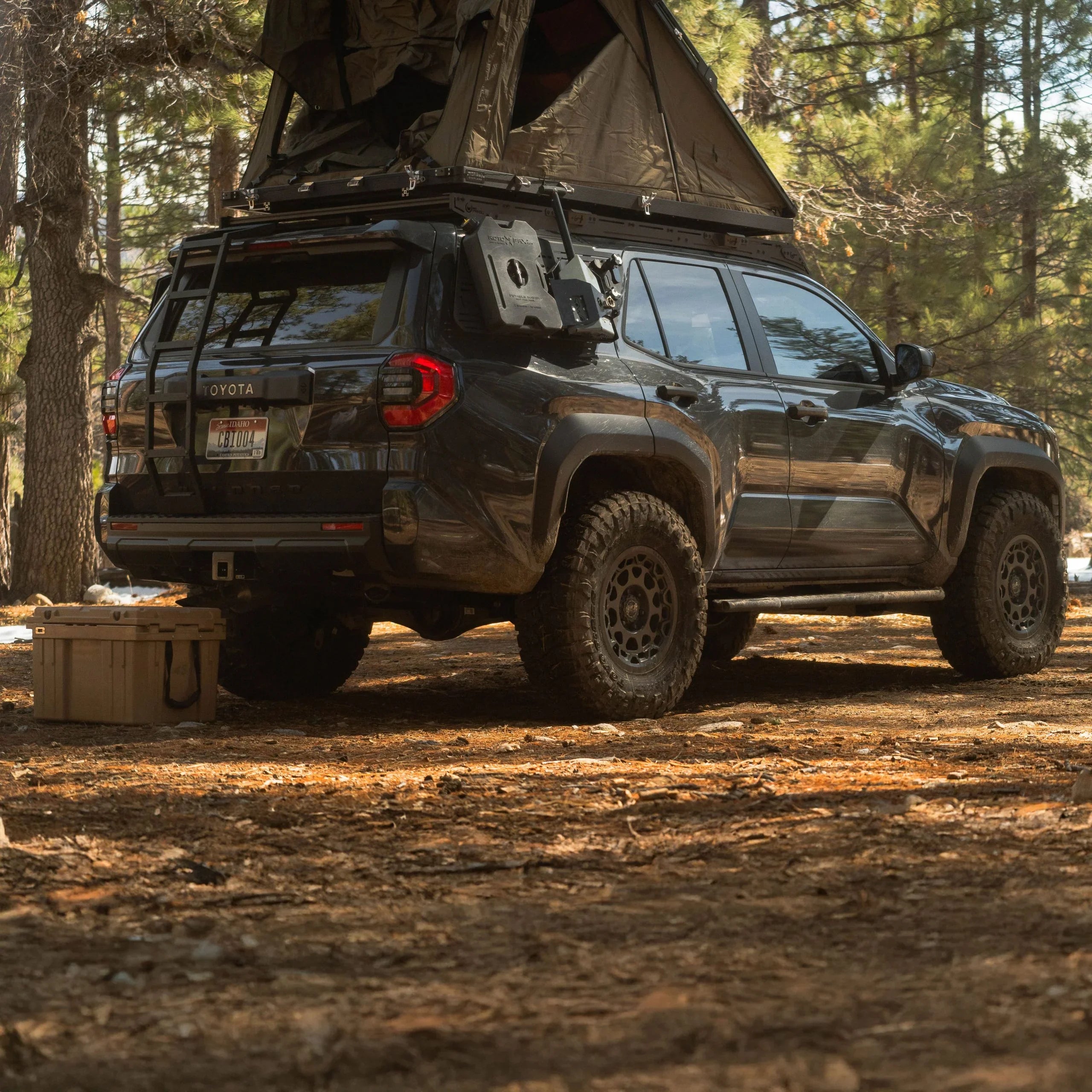 Toyota 4Runner with overlanding ladder and rooftop tent in forest campsite