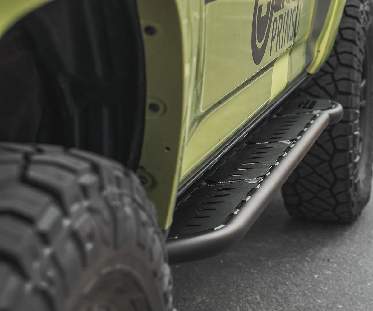 Heavy-duty off-road side step on green SUV with all-terrain tires, ideal for overlanding